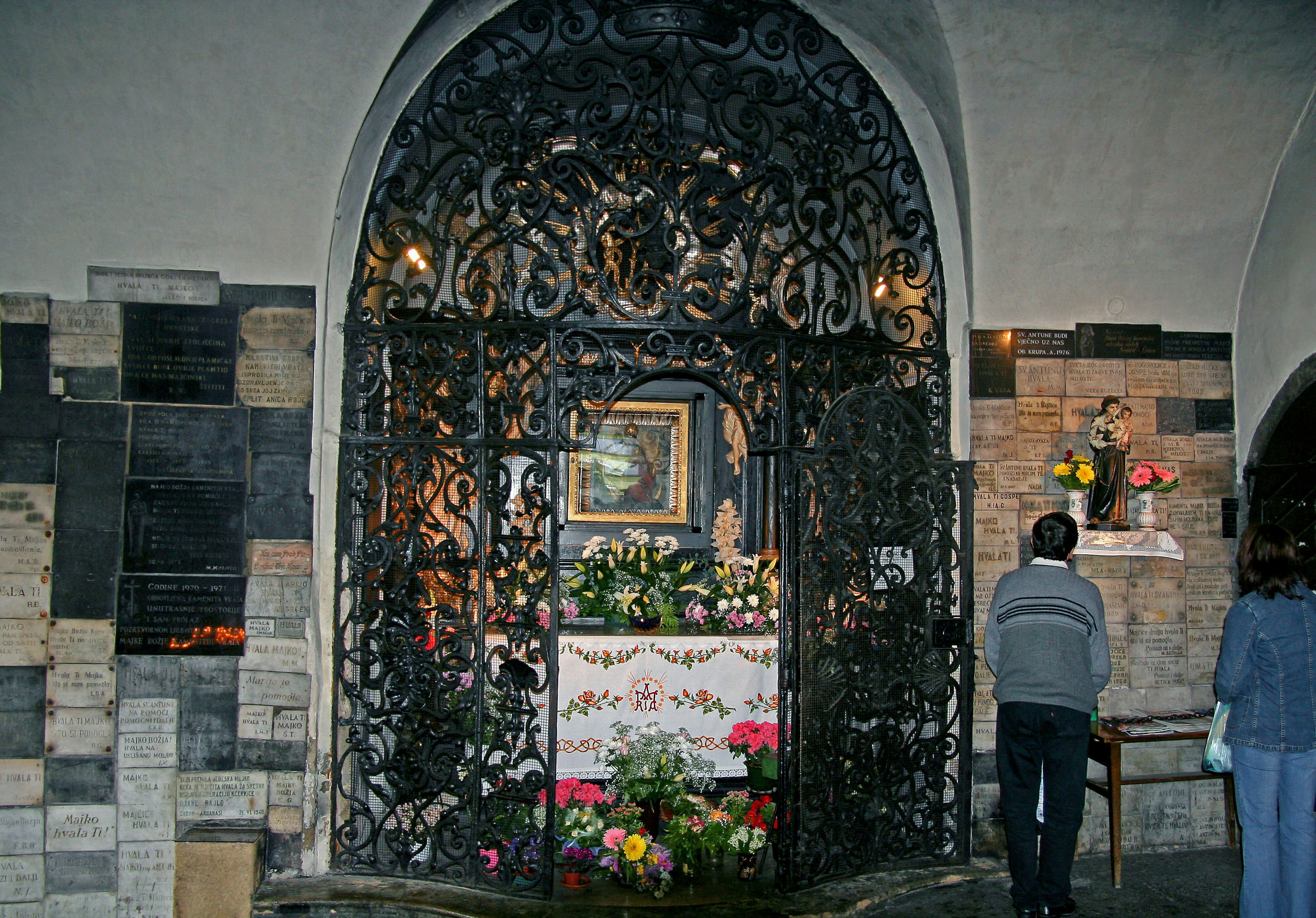 Decorative iron gate with a floral altar in a serene setting