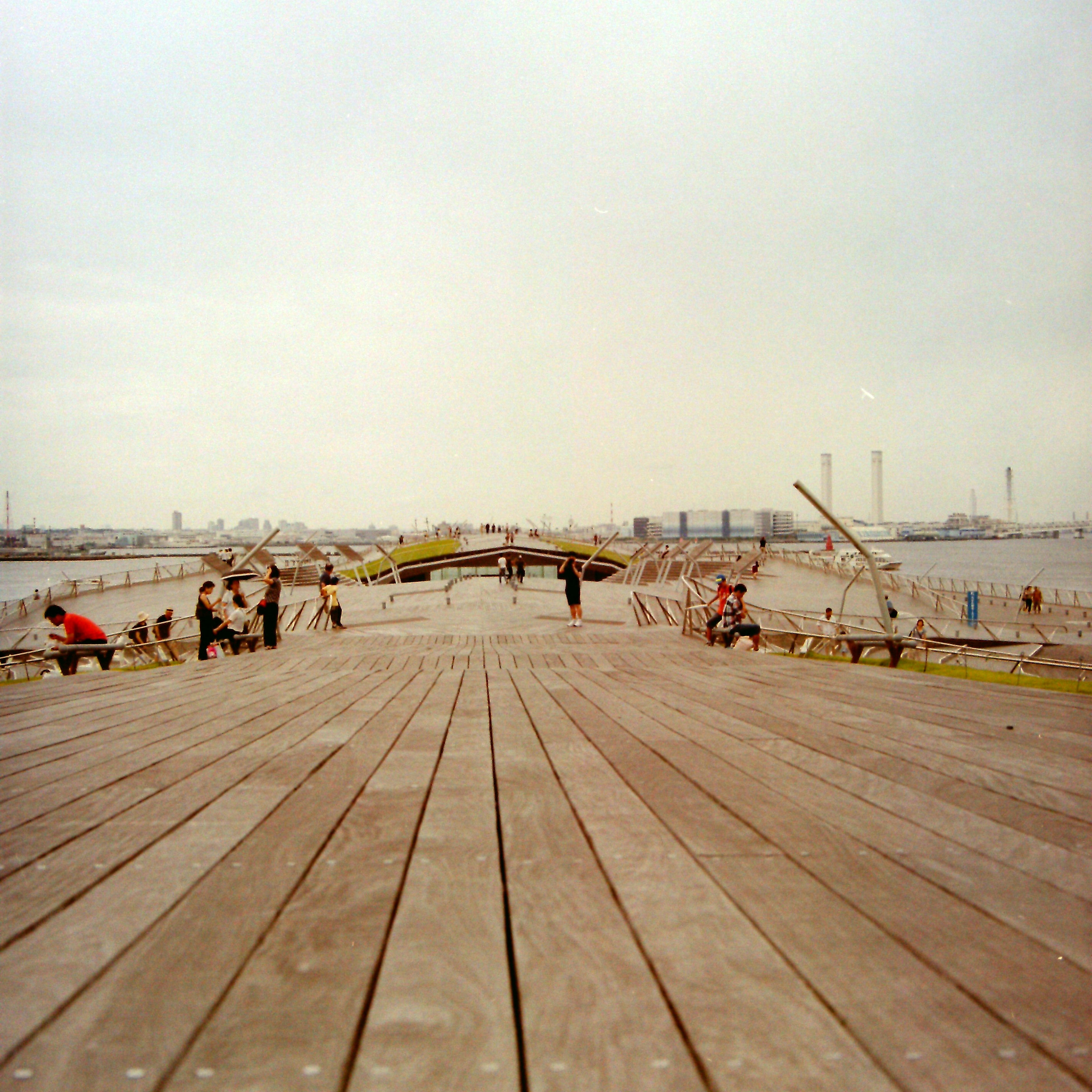 Wooden pier stretching over the sea with people enjoying a calm day