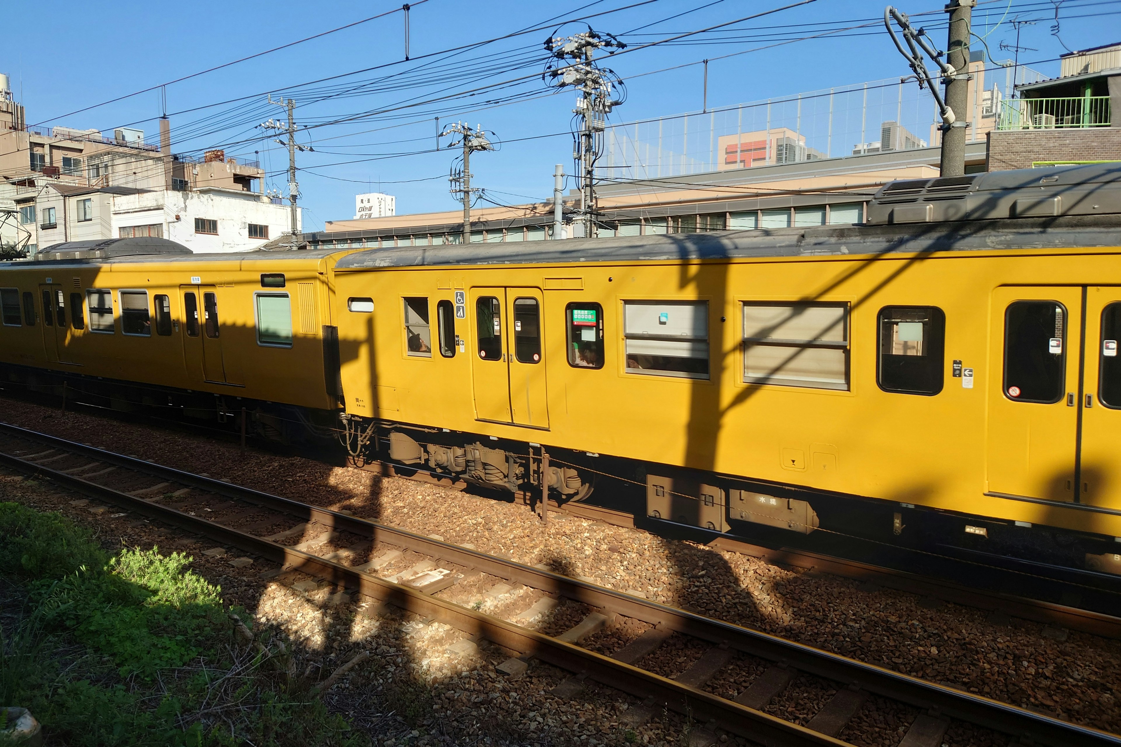 Un treno giallo sui binari con cielo blu chiaro