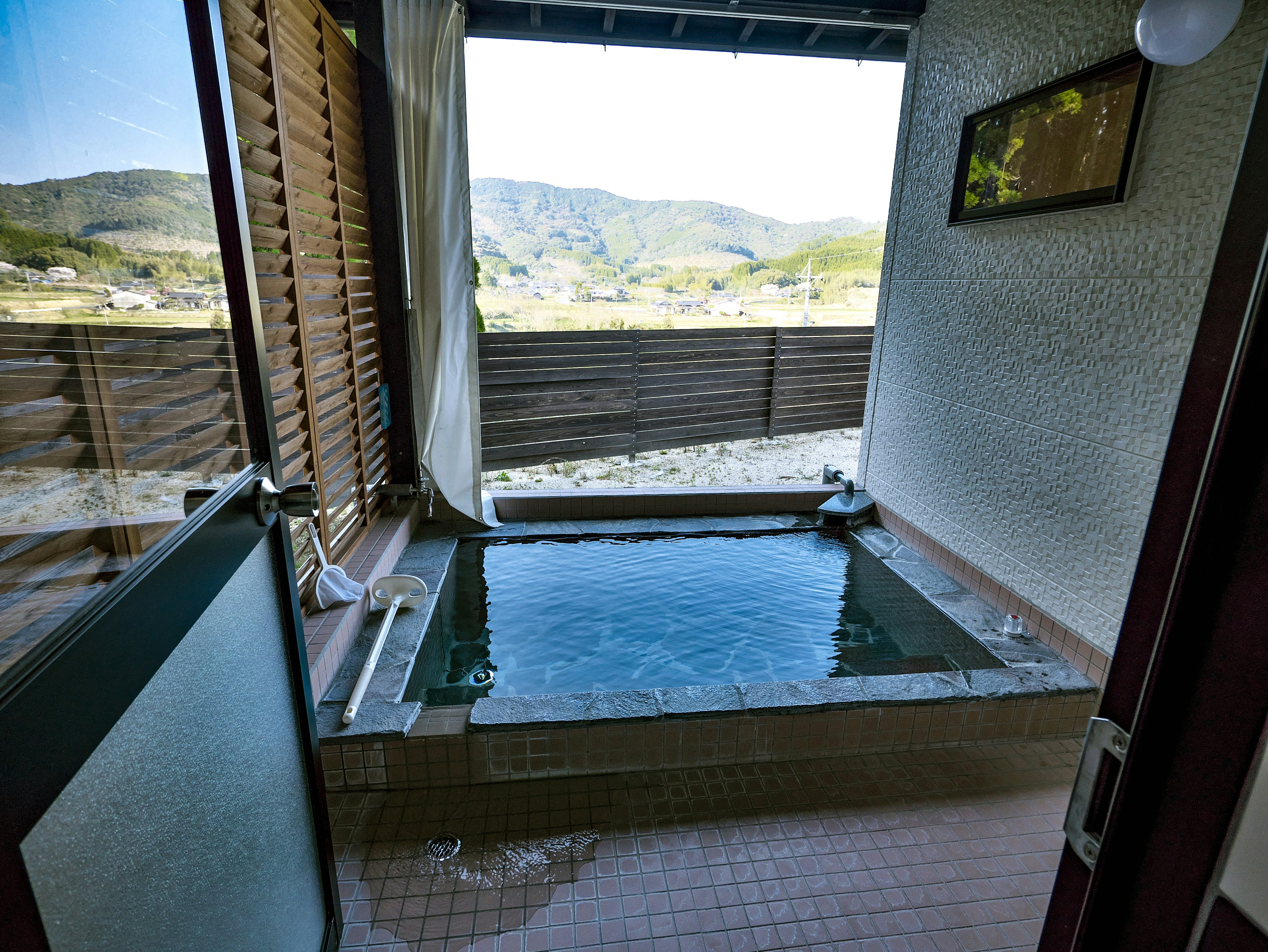 Hot spring bathroom with a view of mountains and nature