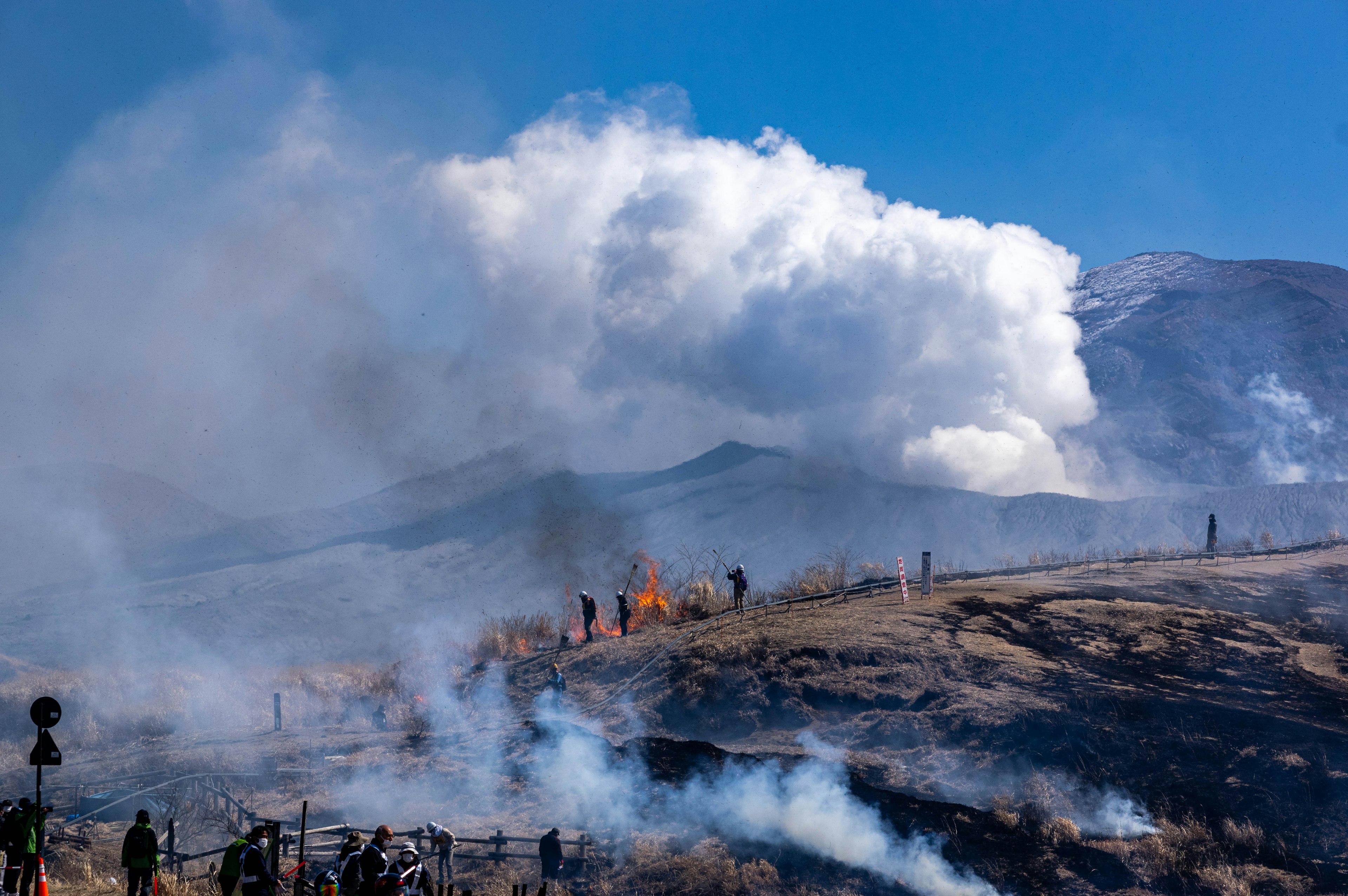 Pemandangan pegunungan dengan kebakaran hutan dan asap yang naik ke langit