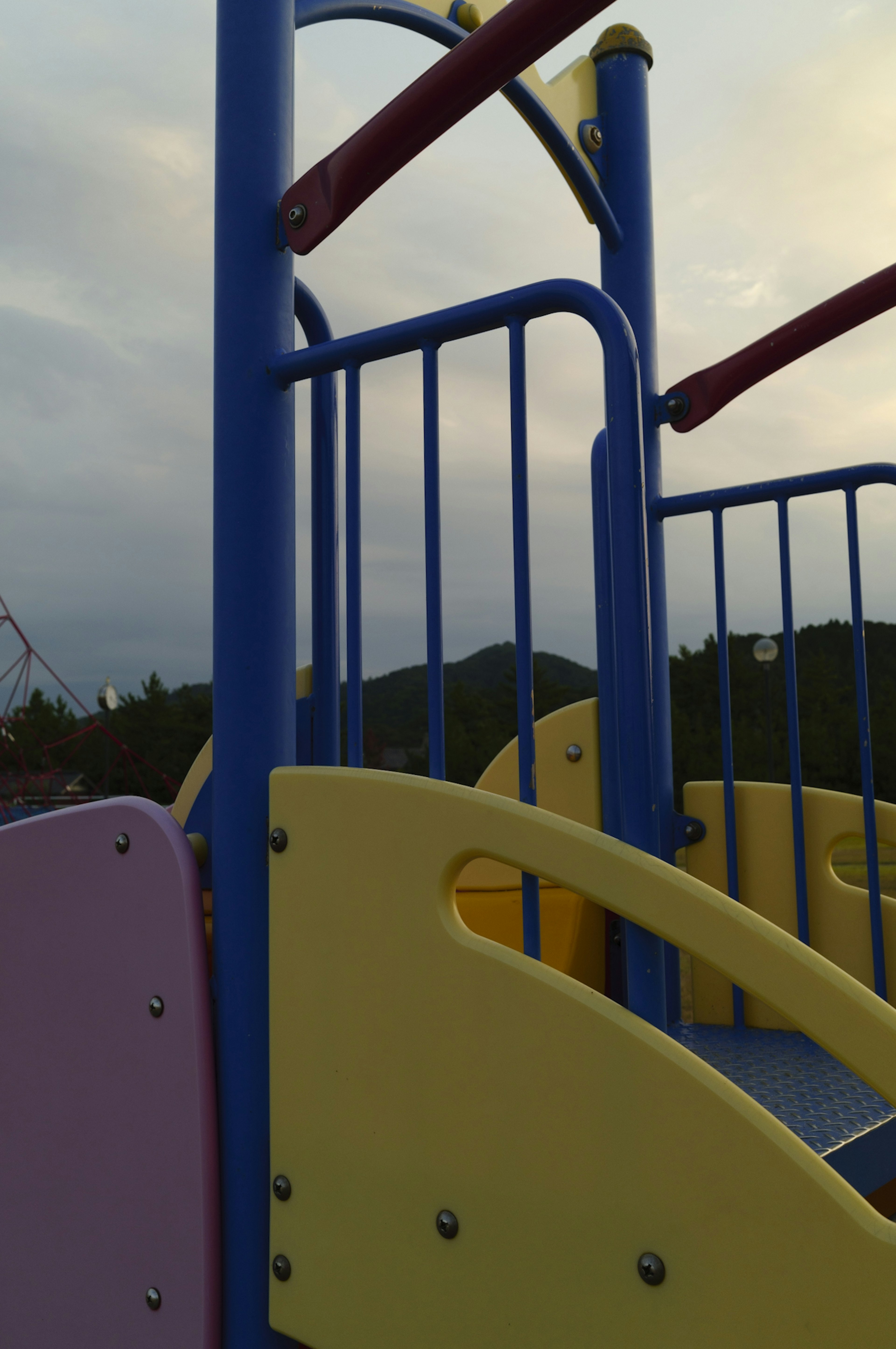 Part of a colorful playground slide with yellow and blue elements