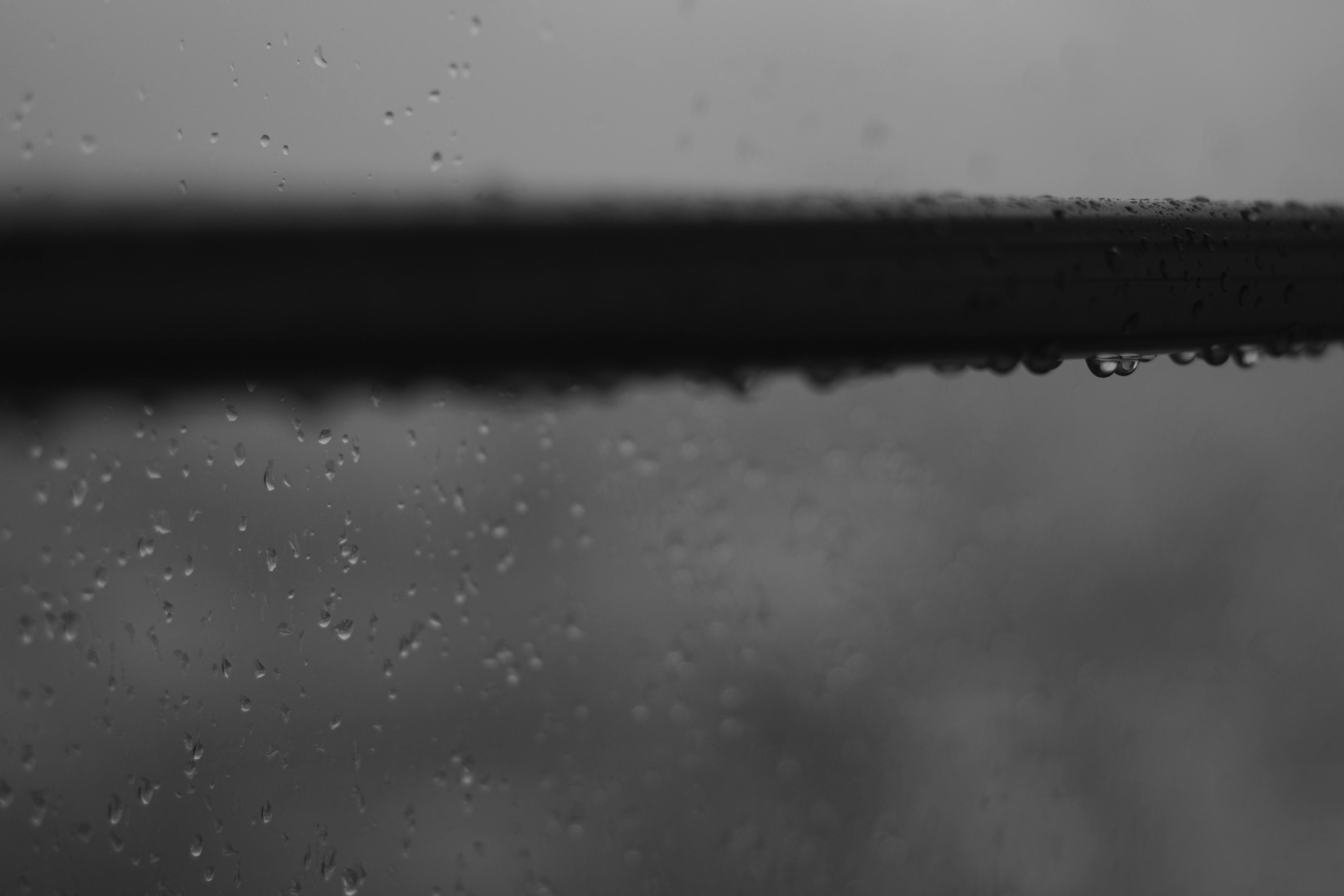 Imagen en blanco y negro de gotas de lluvia en una ventana