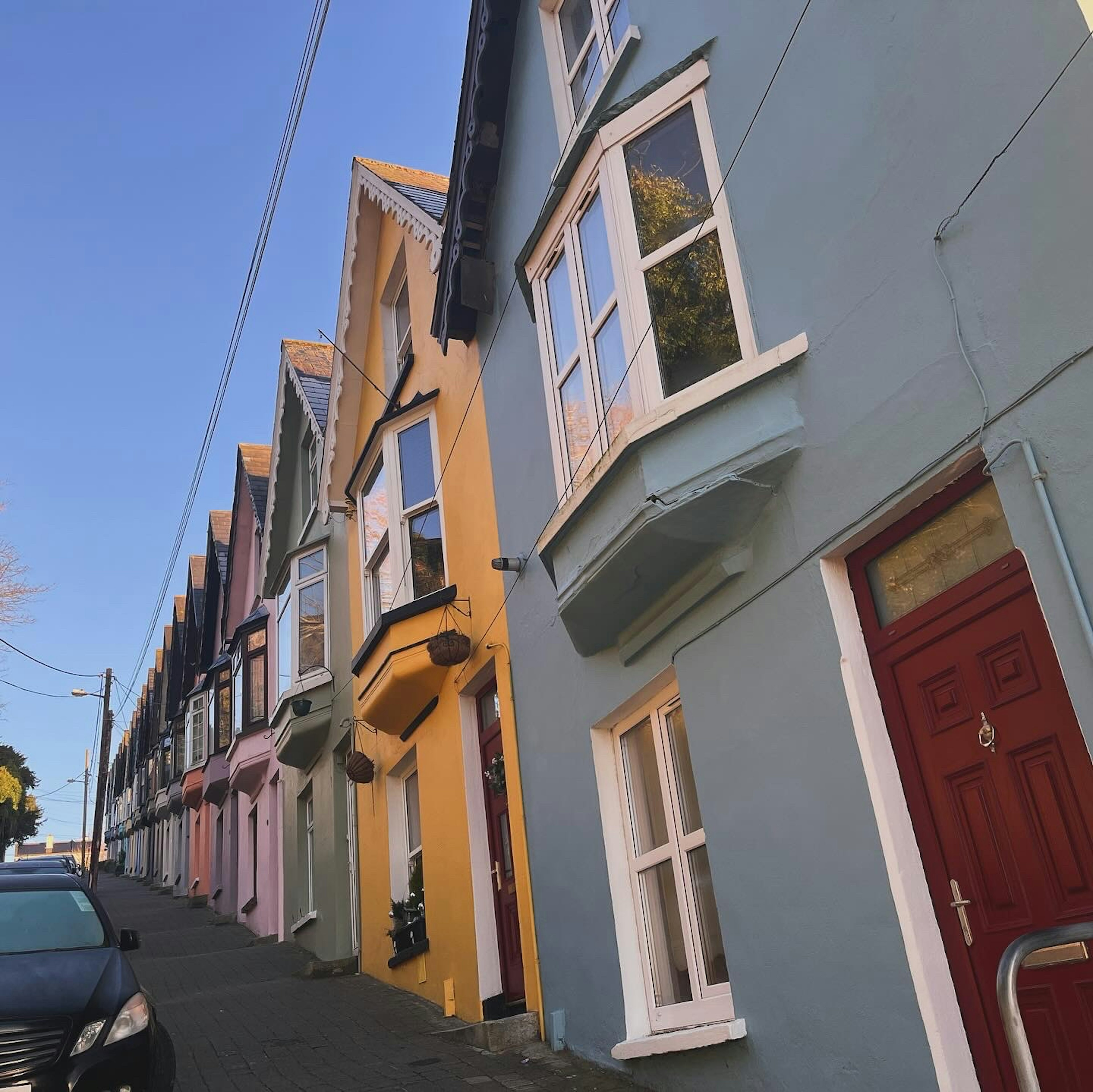 Maisons colorées alignées sur une rue en pente