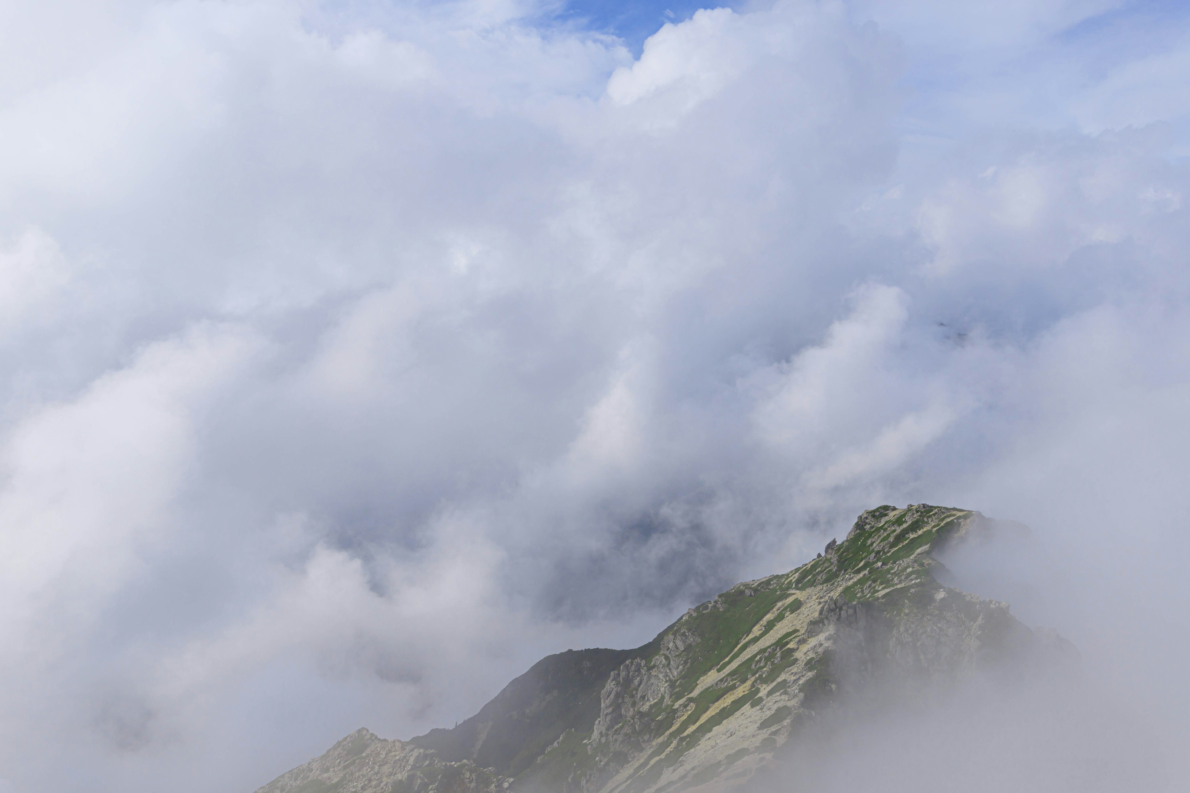 Paesaggio montano avvolto nella nebbia con cielo blu