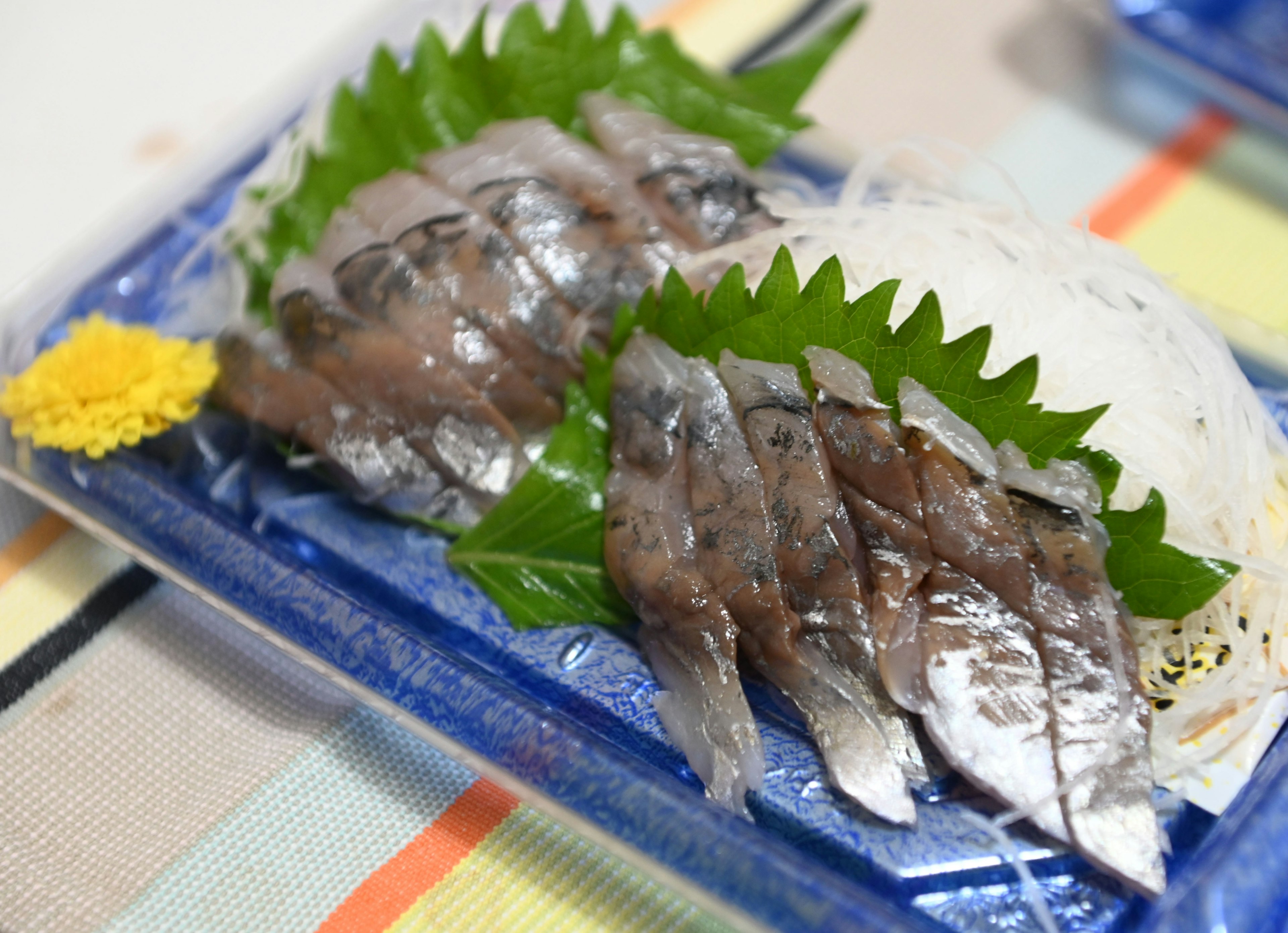 Plate of fresh sashimi garnished with shiso leaves