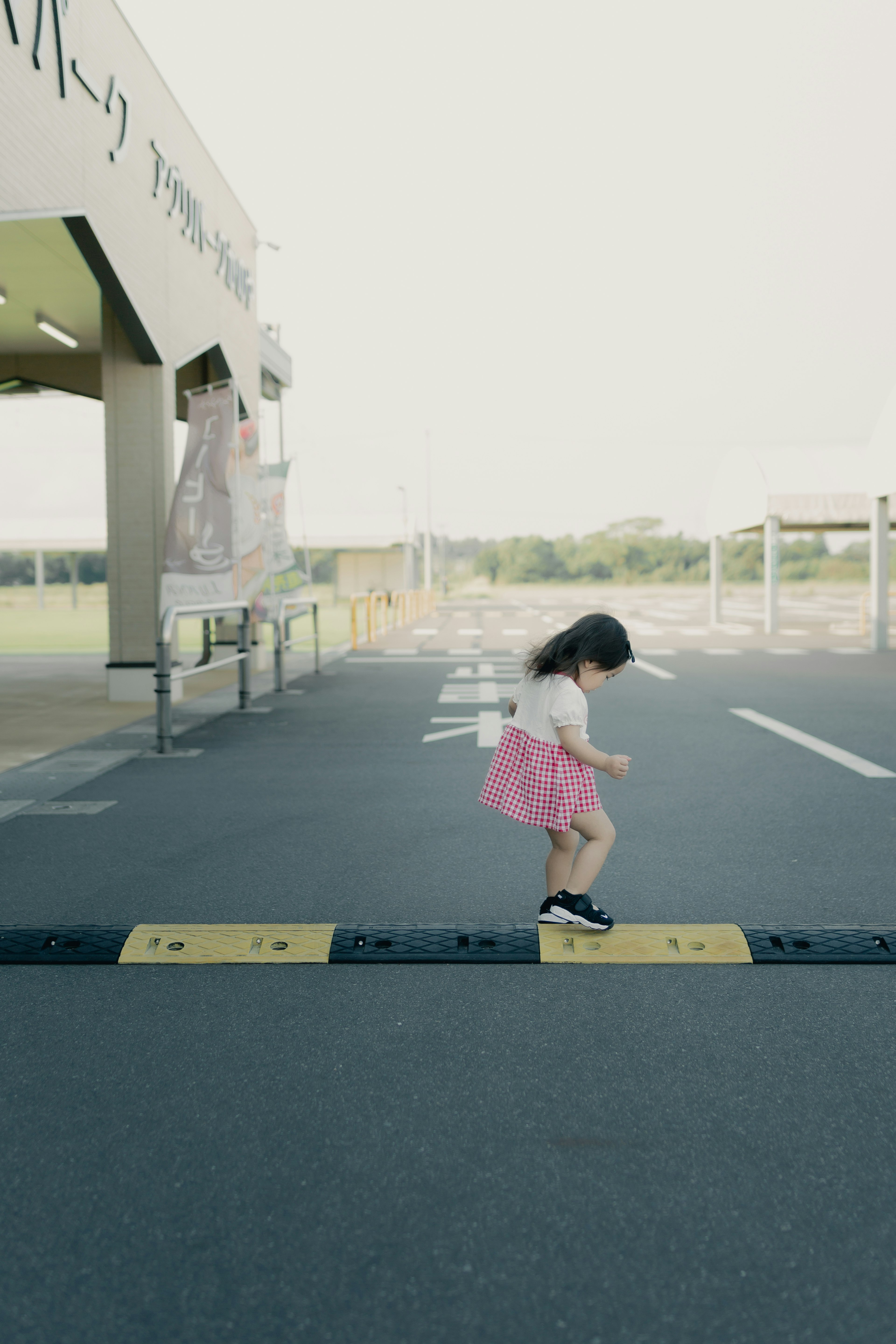 Una niña con una falda rosa caminando sobre un paso peatonal