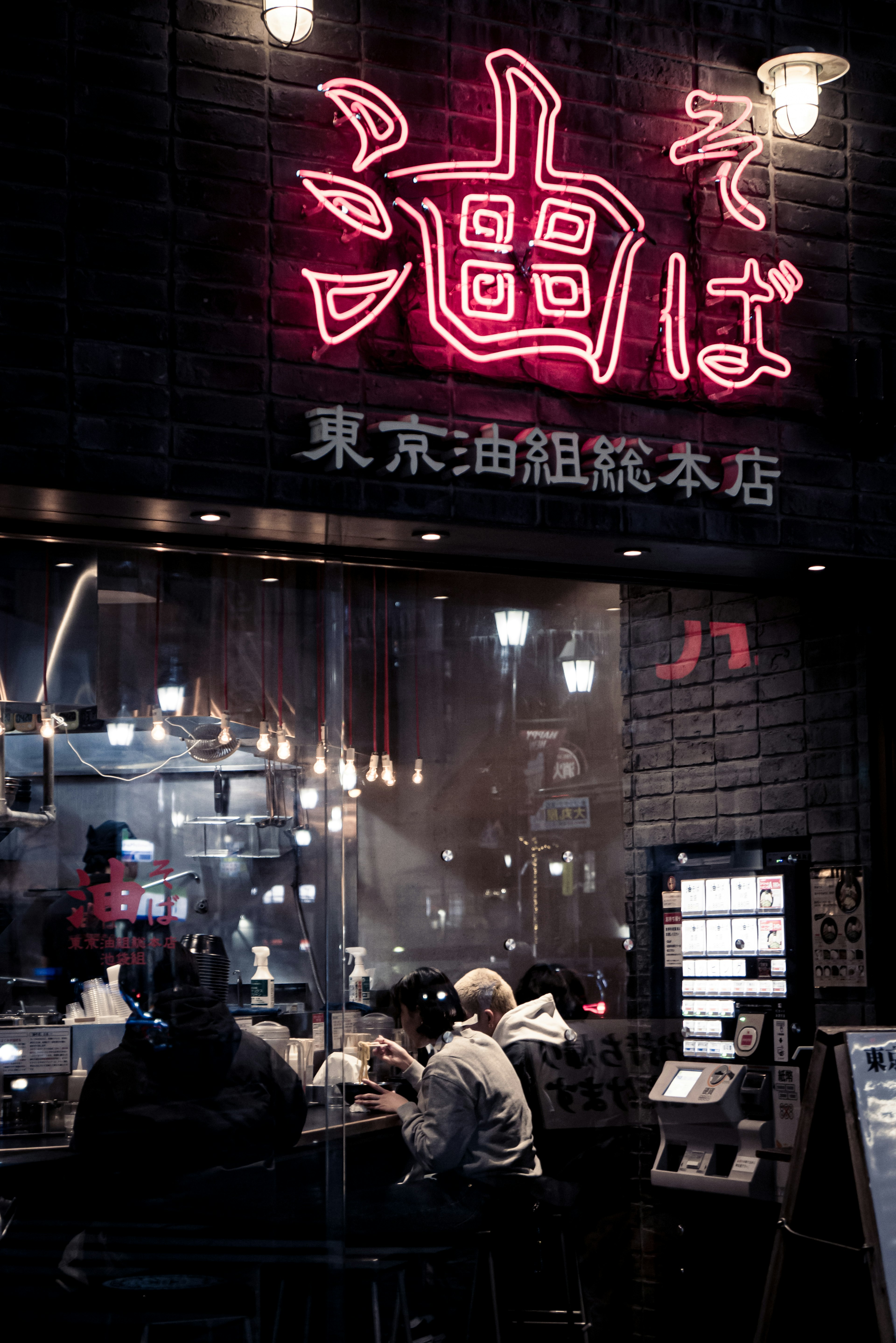 Esterno di un ristorante di ramen a Tokyo con insegna al neon luminosa