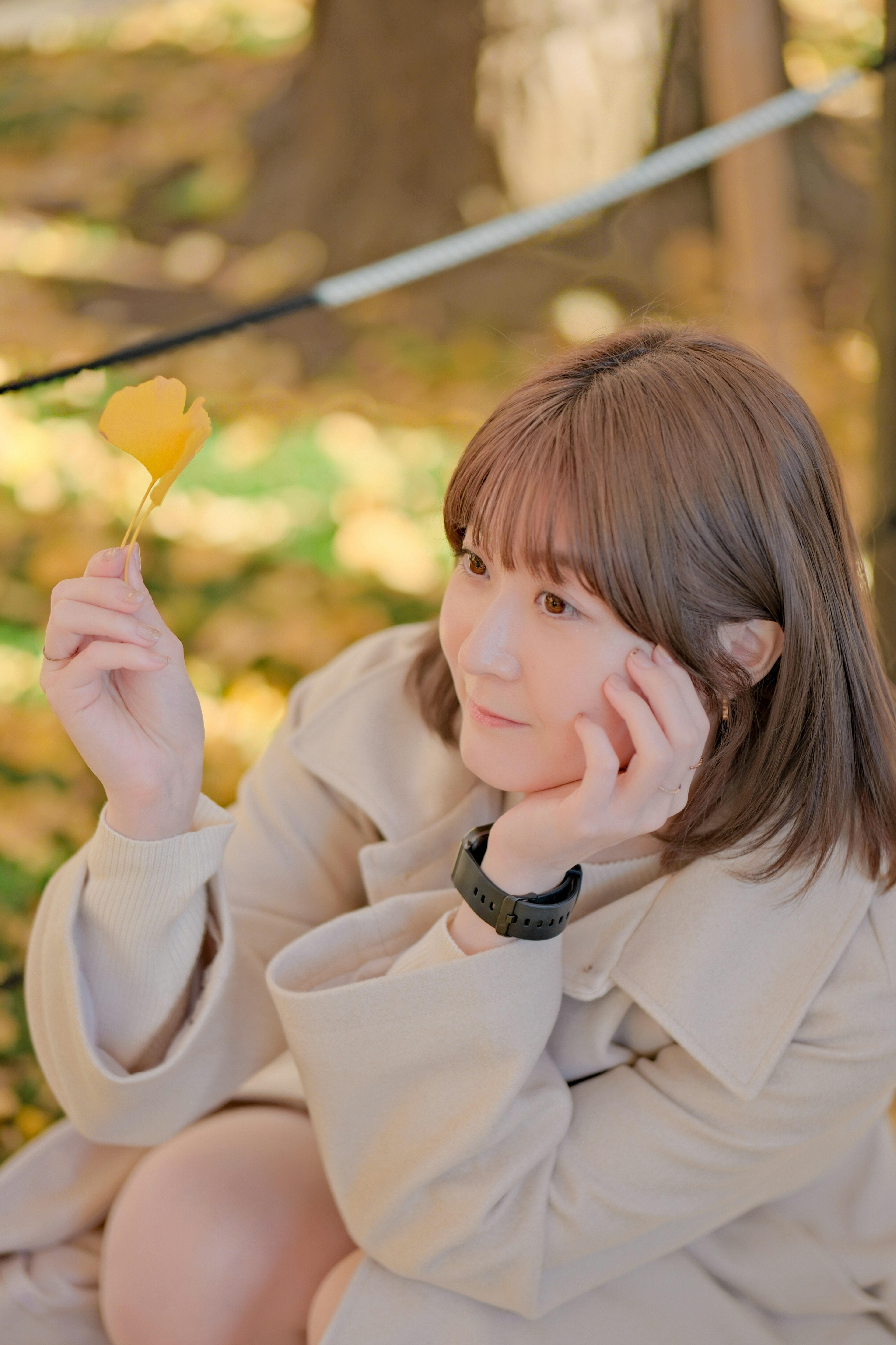 秋の葉を持つ女性のポートレート　柔らかな光と背景のぼかし