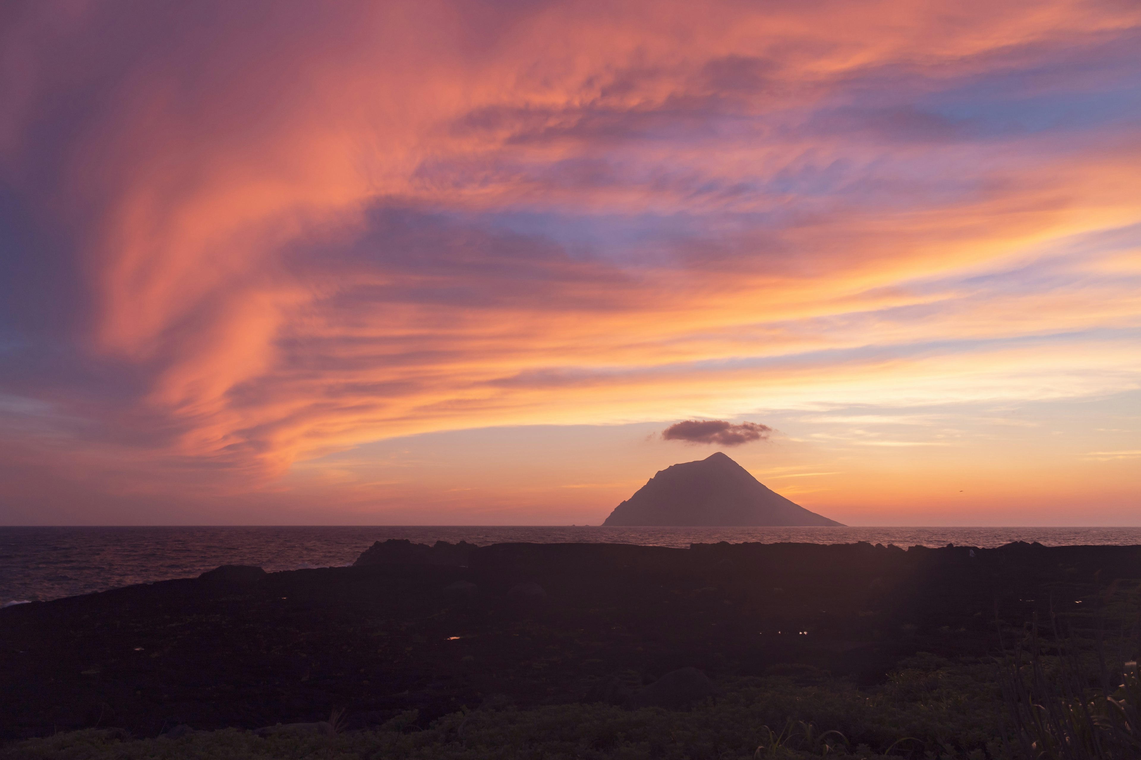 Vista escénica de un volcán al atardecer con nubes vibrantes