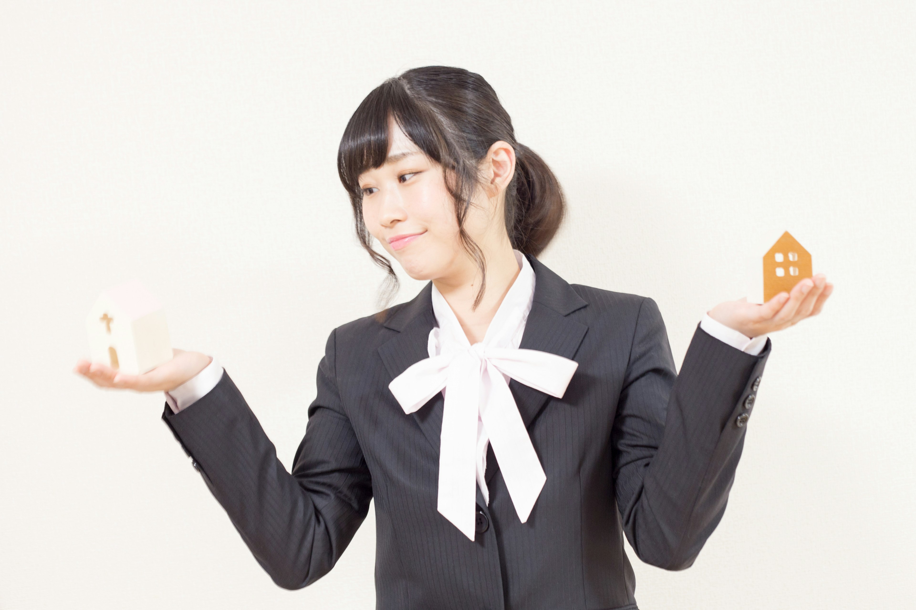 Woman holding house-shaped objects against a white background