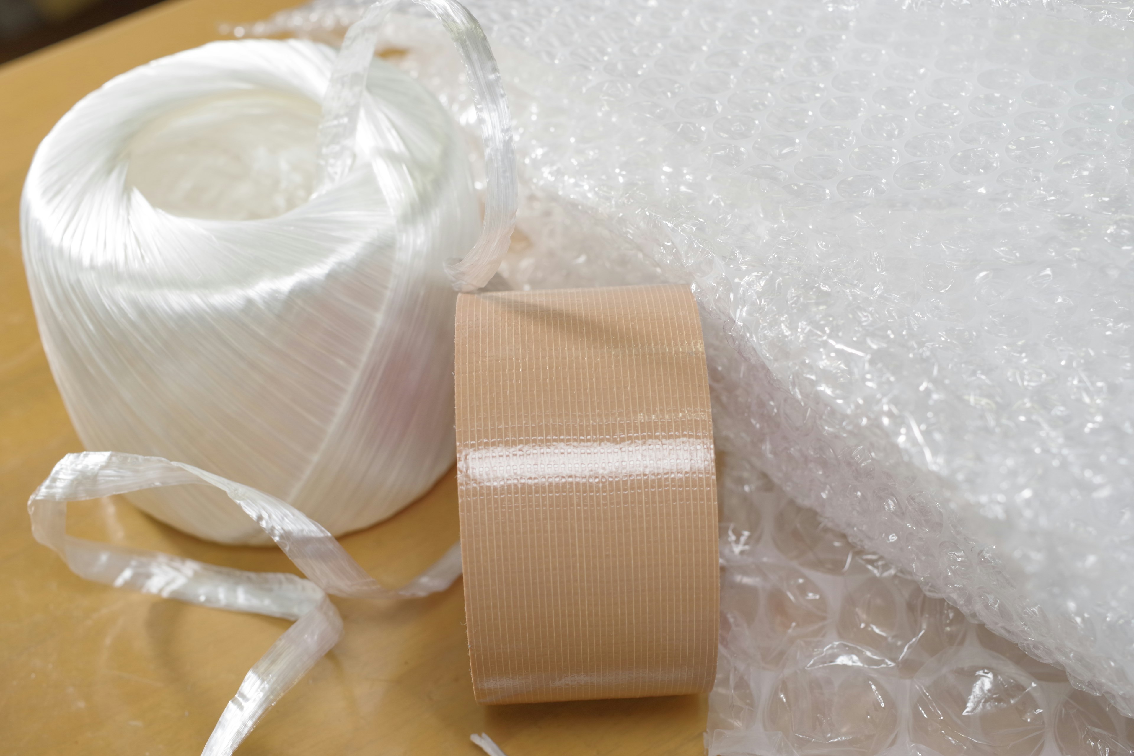 White ribbon and brown tape placed next to bubble wrap