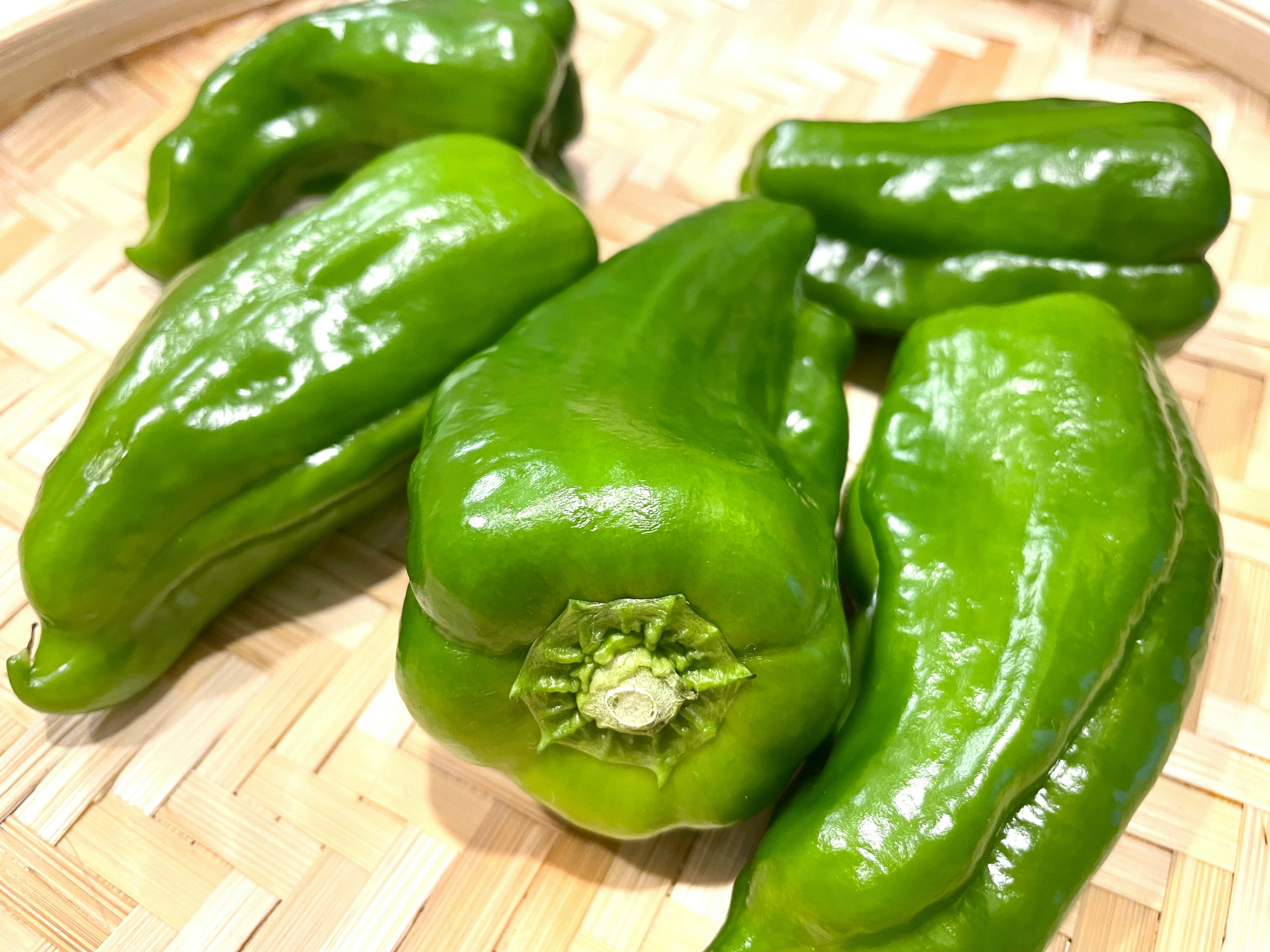 Green bell peppers arranged in a woven basket