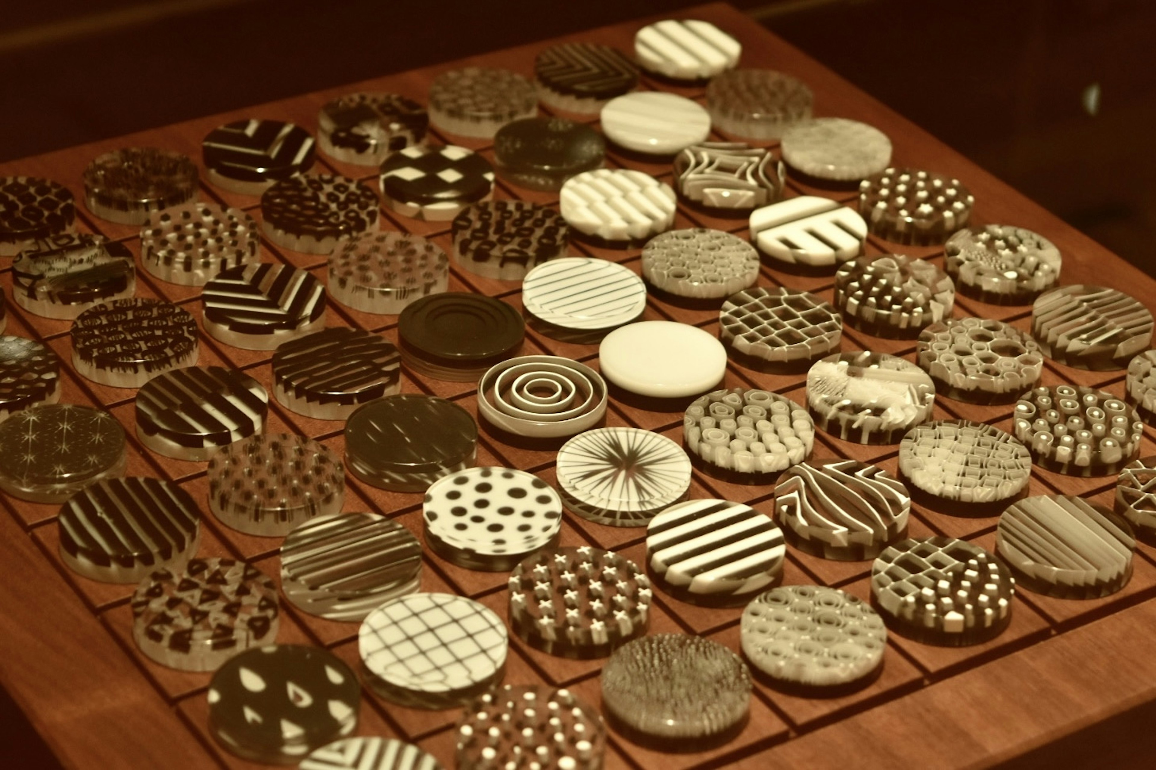 A wooden board displaying circular tiles with black and white patterns