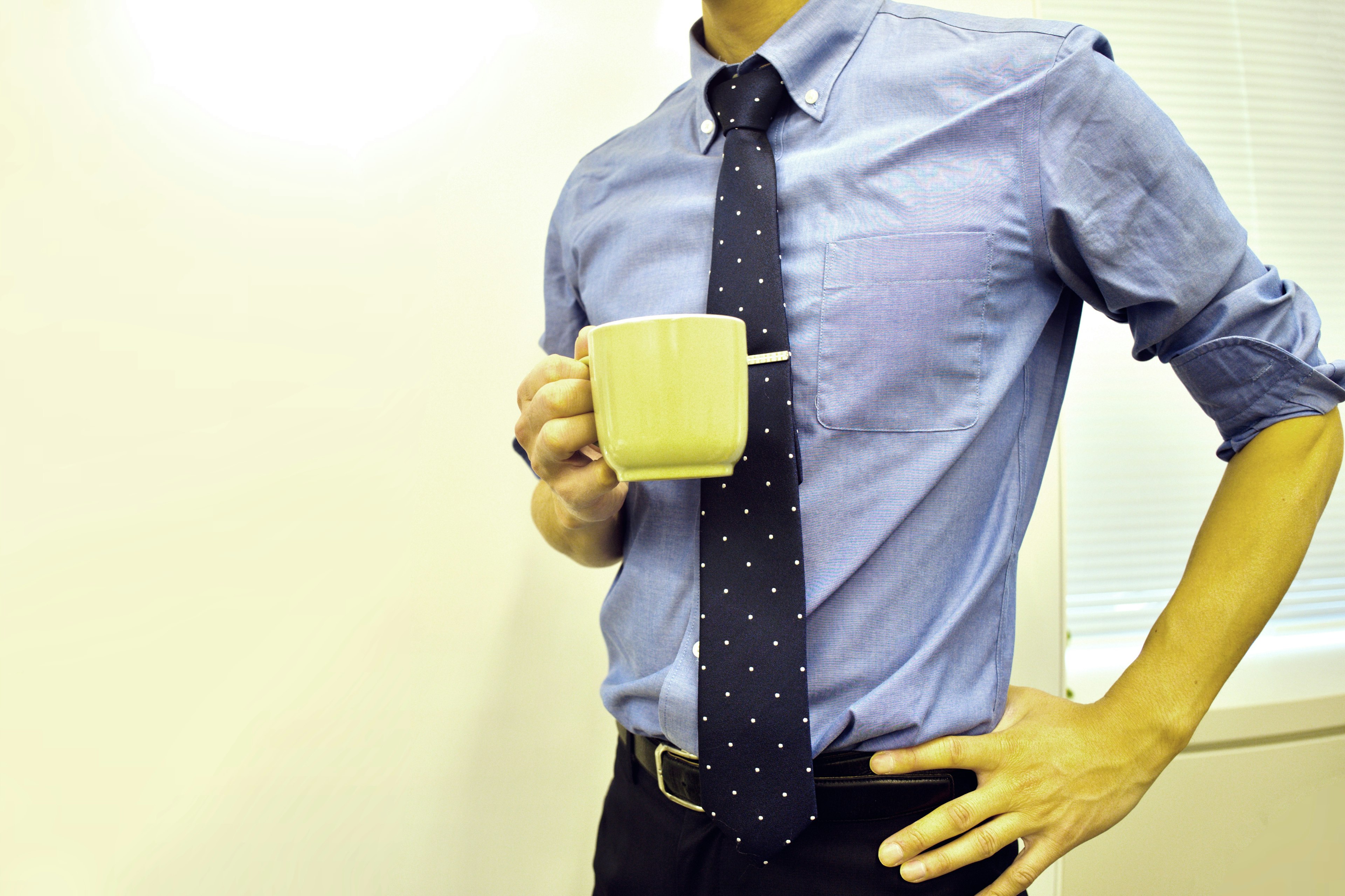 Man in blue shirt holding a coffee cup