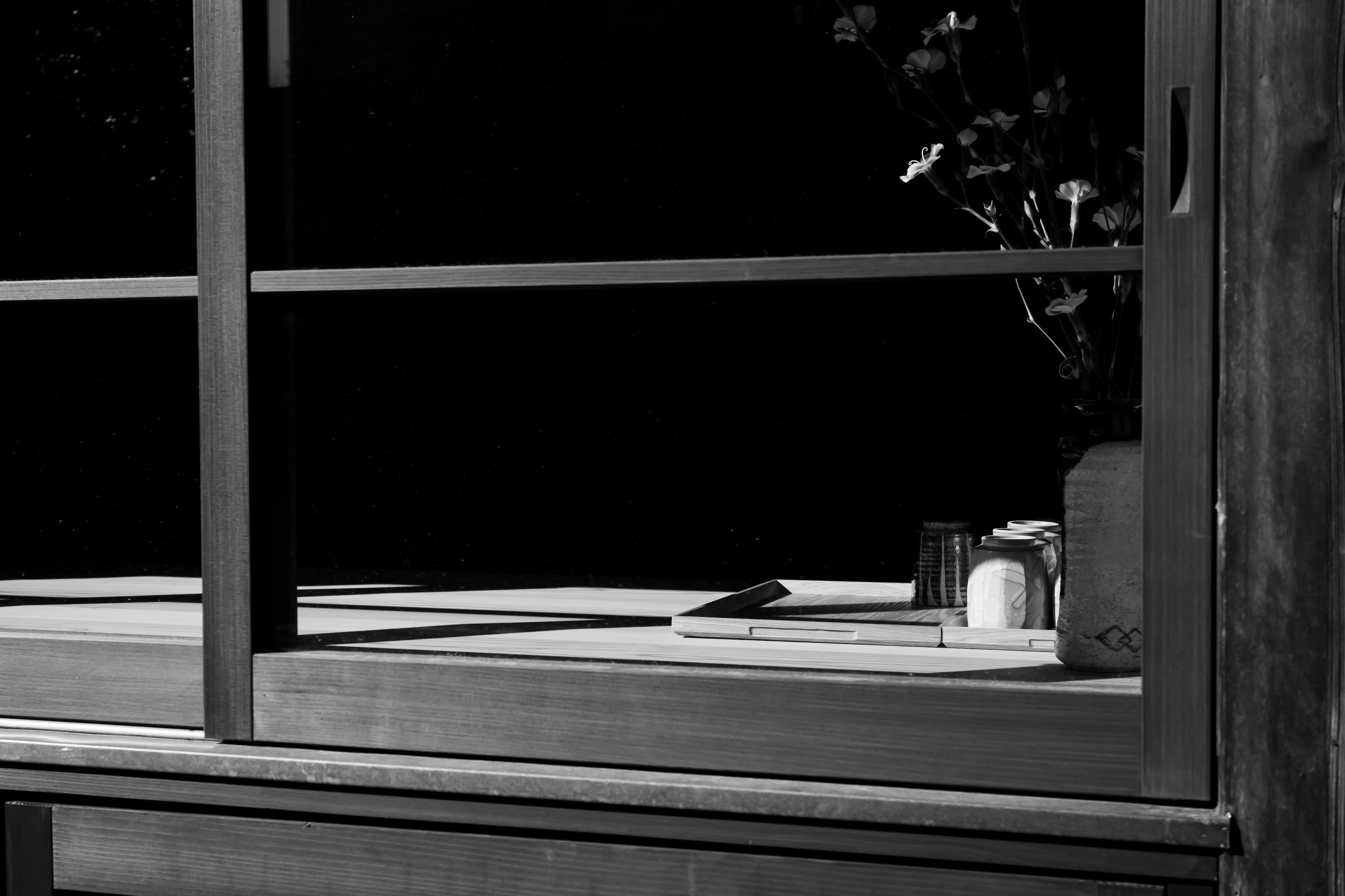 Table and objects in front of a window with a black background