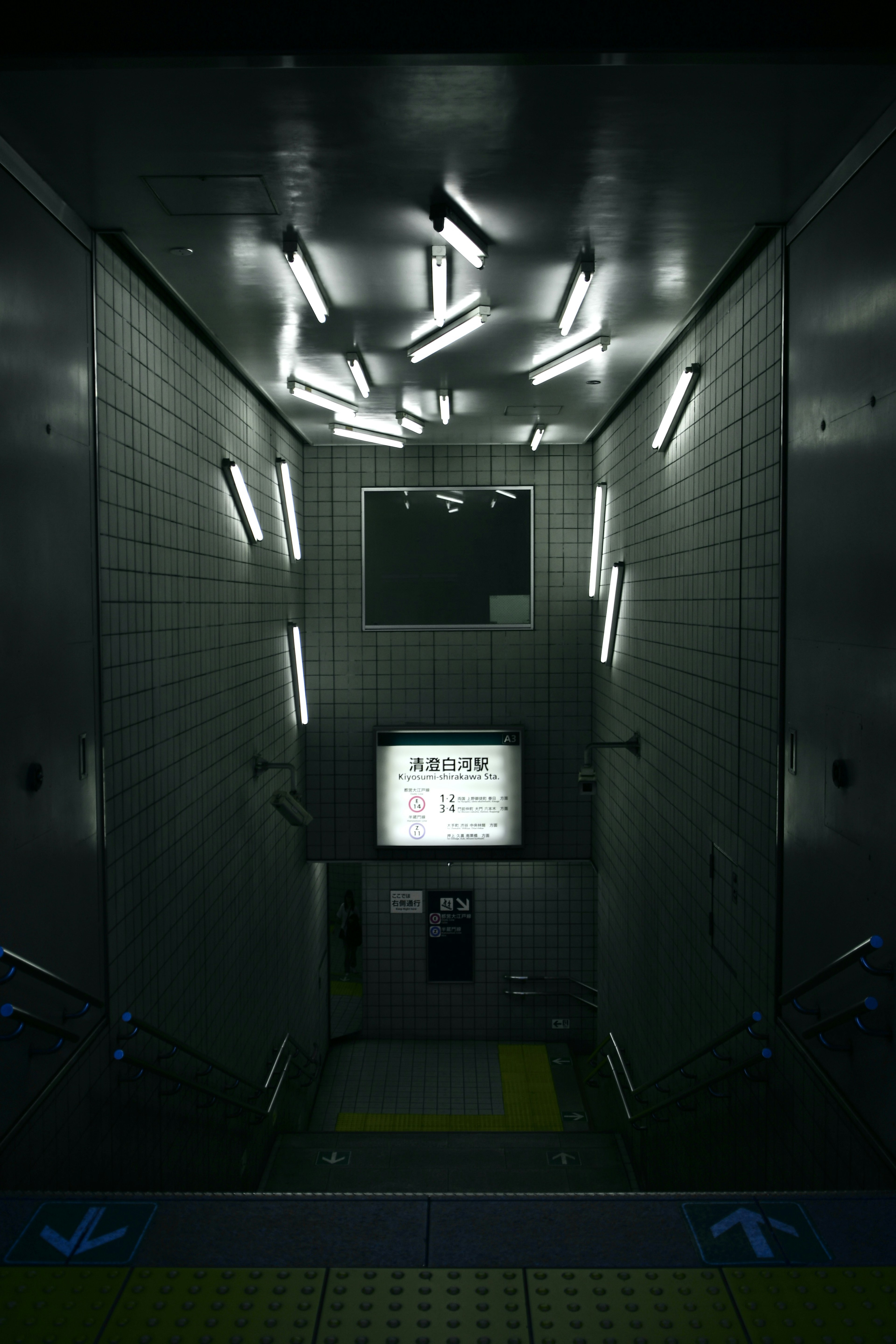 Dimly lit corridor with fluorescent lights and electronic display