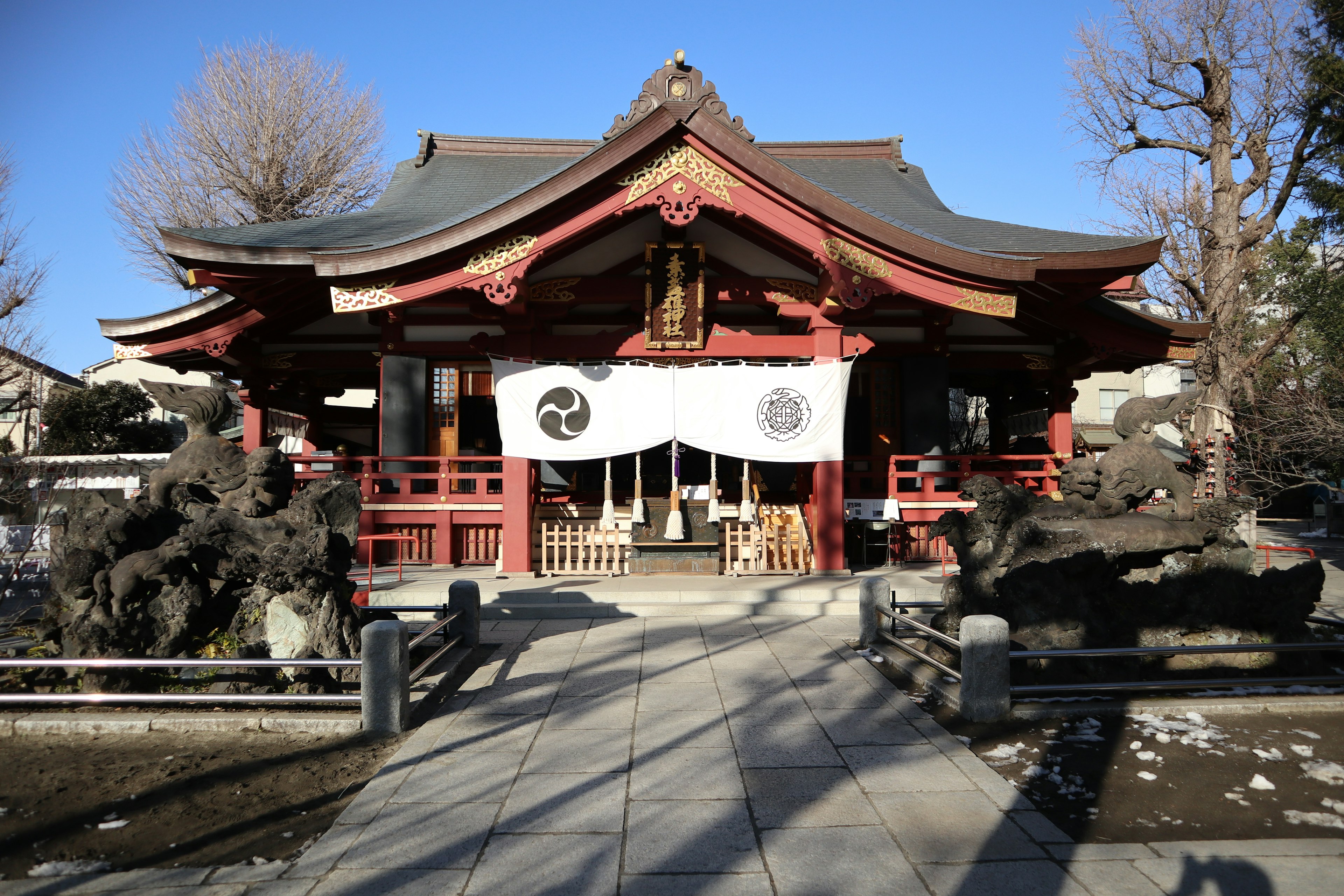 在晴朗藍天下的紅色屋頂和白色幕布的神社