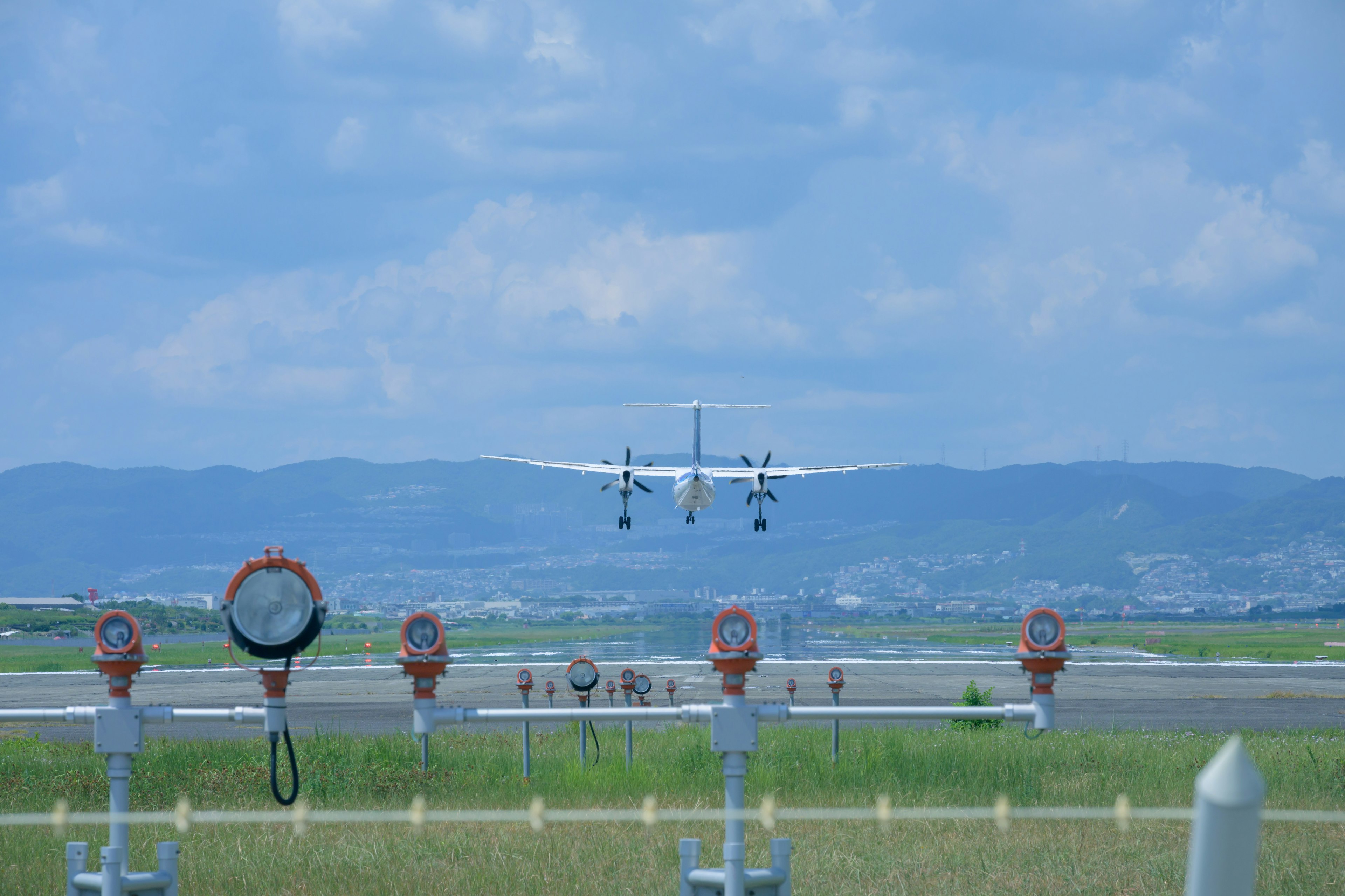 Airplane landing on runway with surrounding scenery