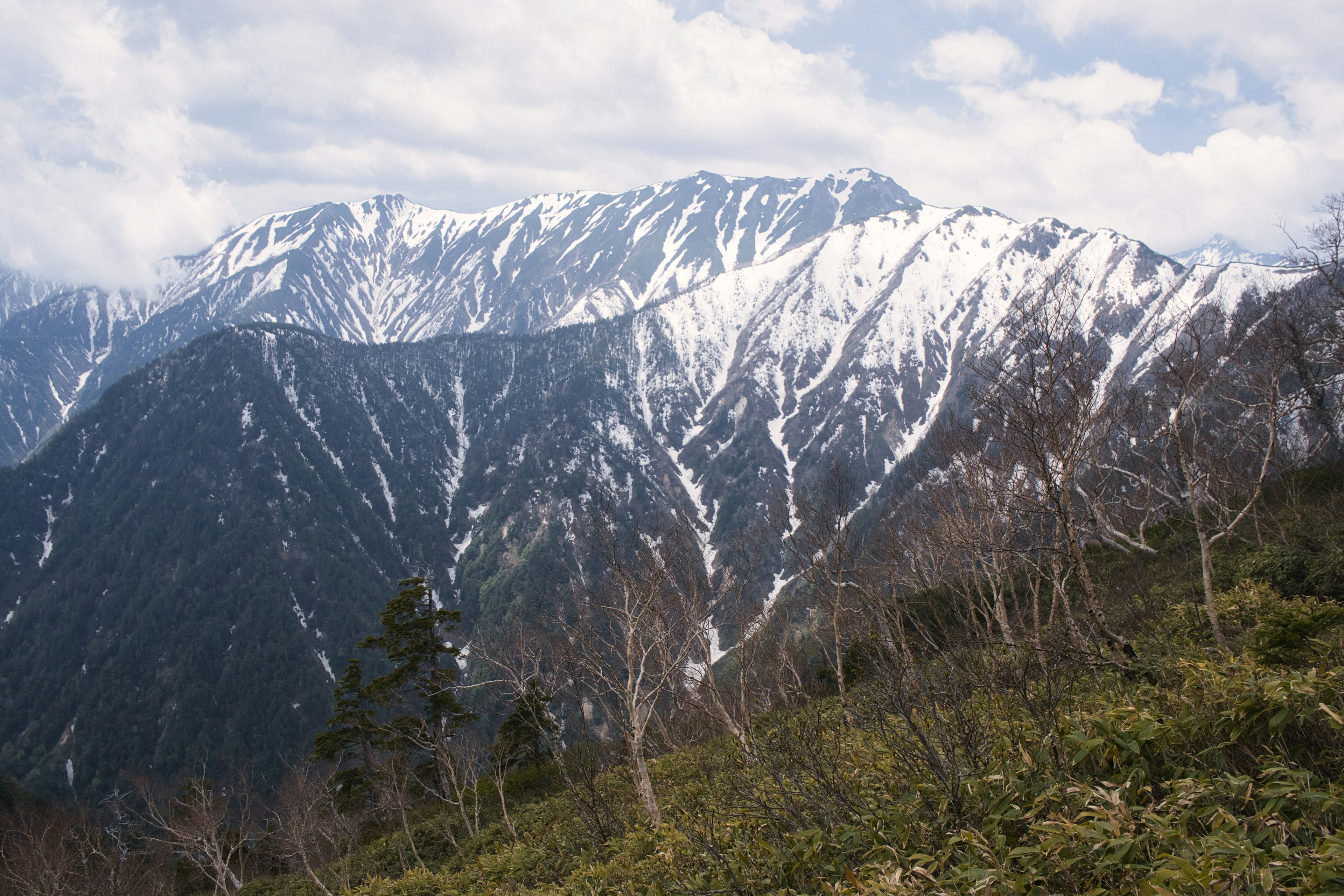 Vista panoramica di montagne innevate sotto un cielo nuvoloso