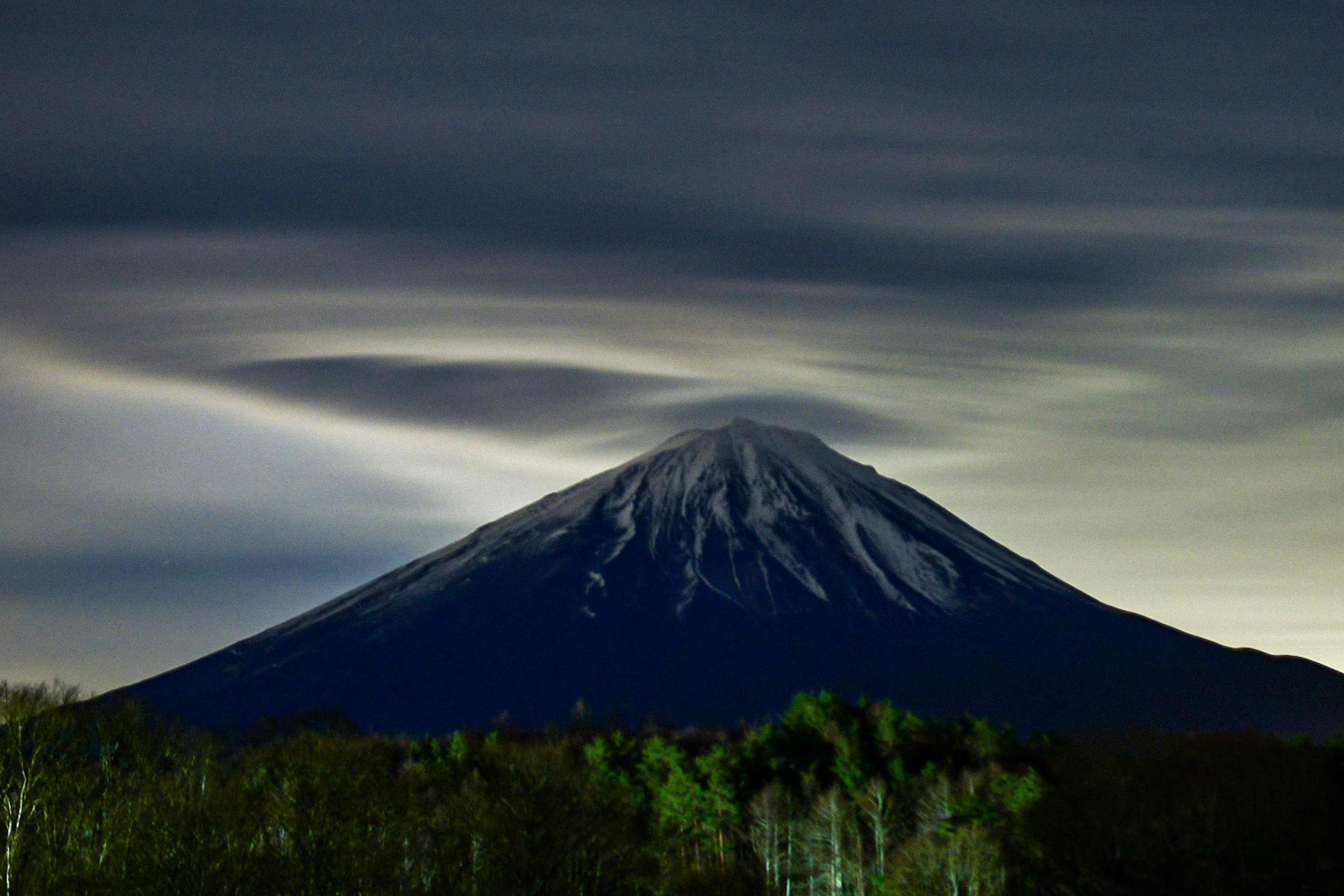 Hermoso monte Fuji iluminado de noche con nubes