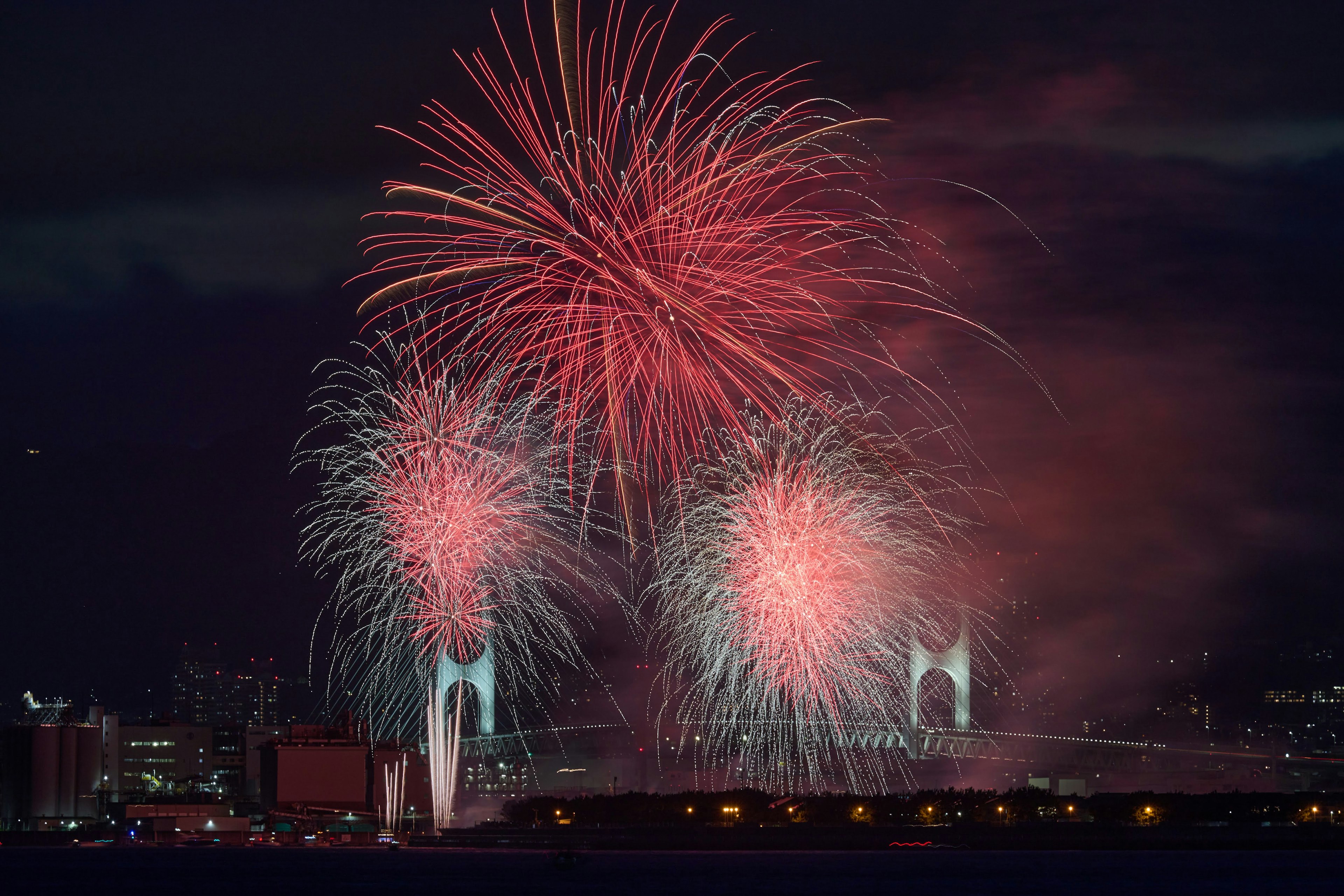 Spectacle de feux d'artifice colorés contre un ciel nocturne avec des lumières de la ville