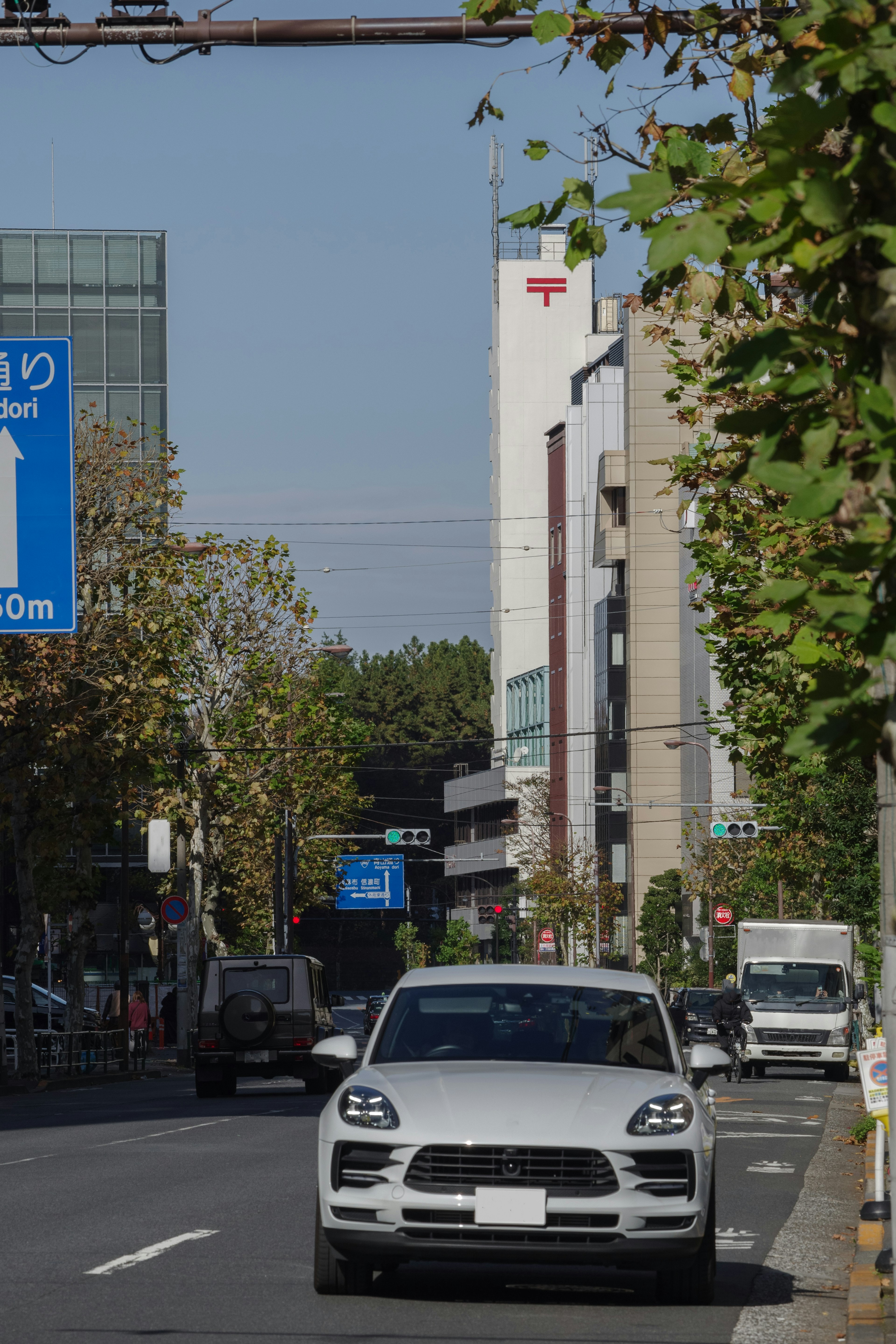 City street scene with a white car driving