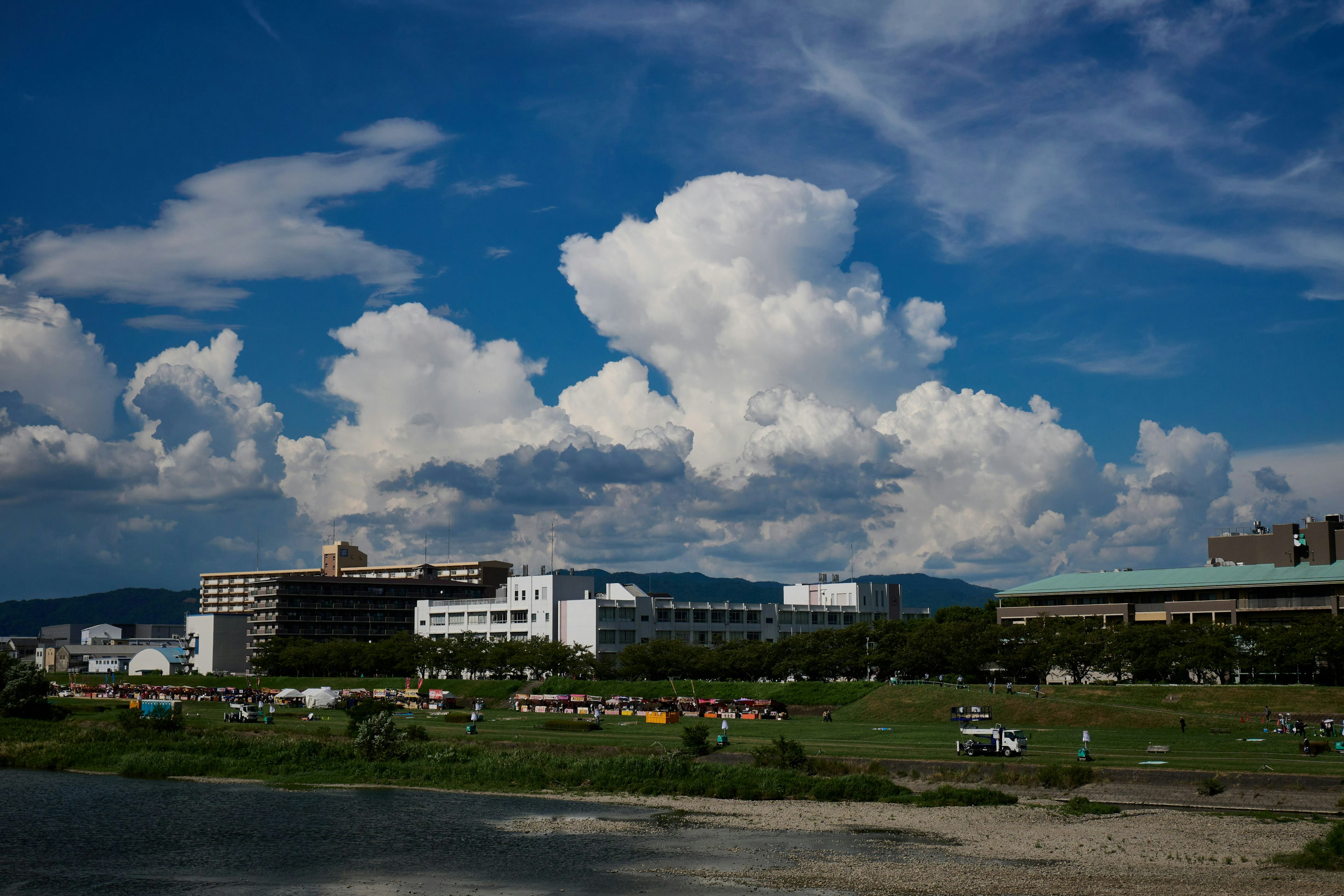 Paysage fluvial avec ciel bleu et nuages mettant en valeur des bâtiments