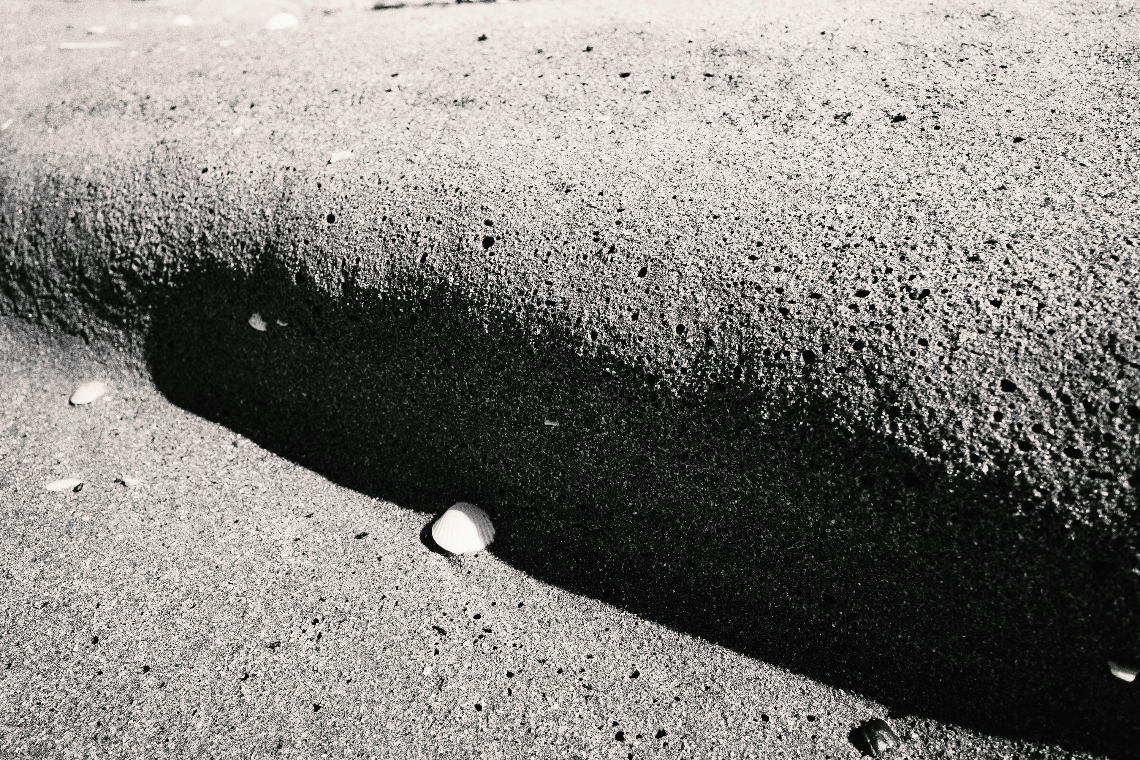 Contrast of a groove and small stones on a sandy surface