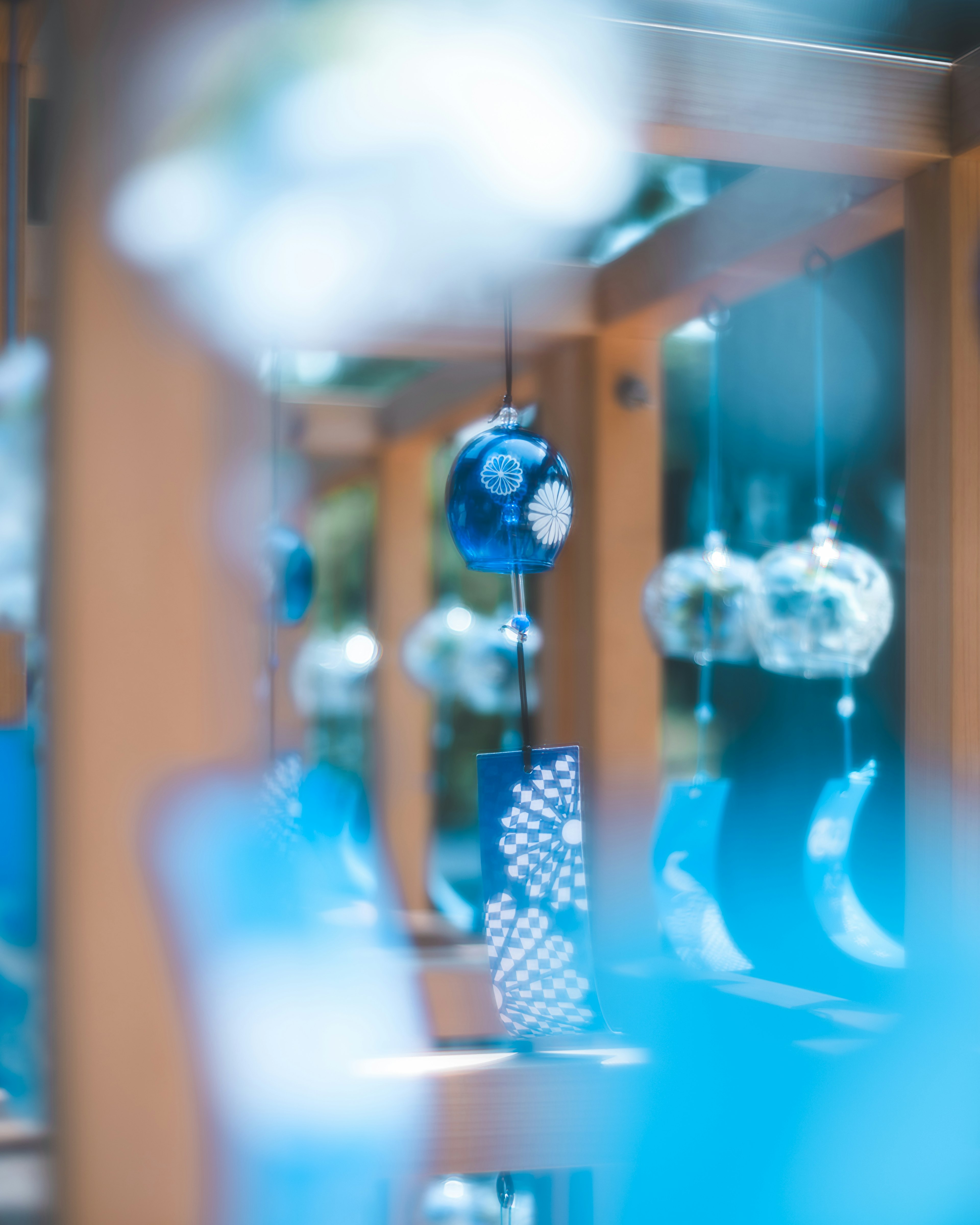 Photo of blue wind chimes hanging from a wooden structure