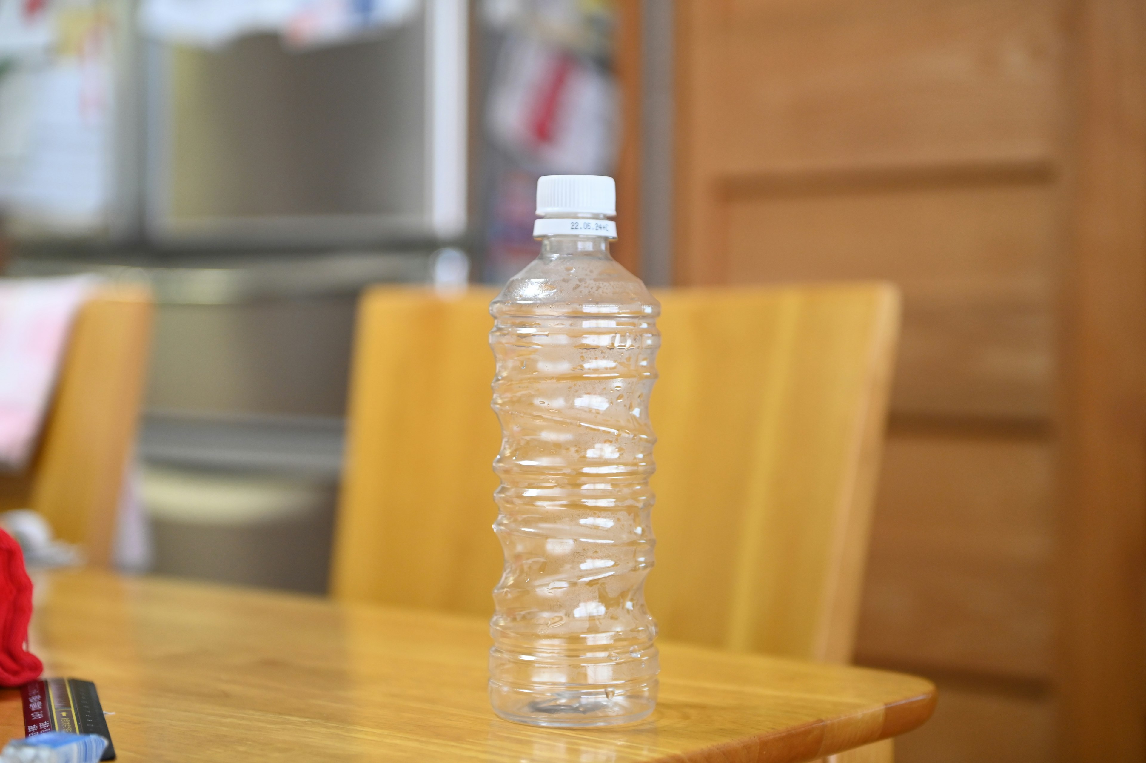 A clear plastic bottle standing on a wooden table