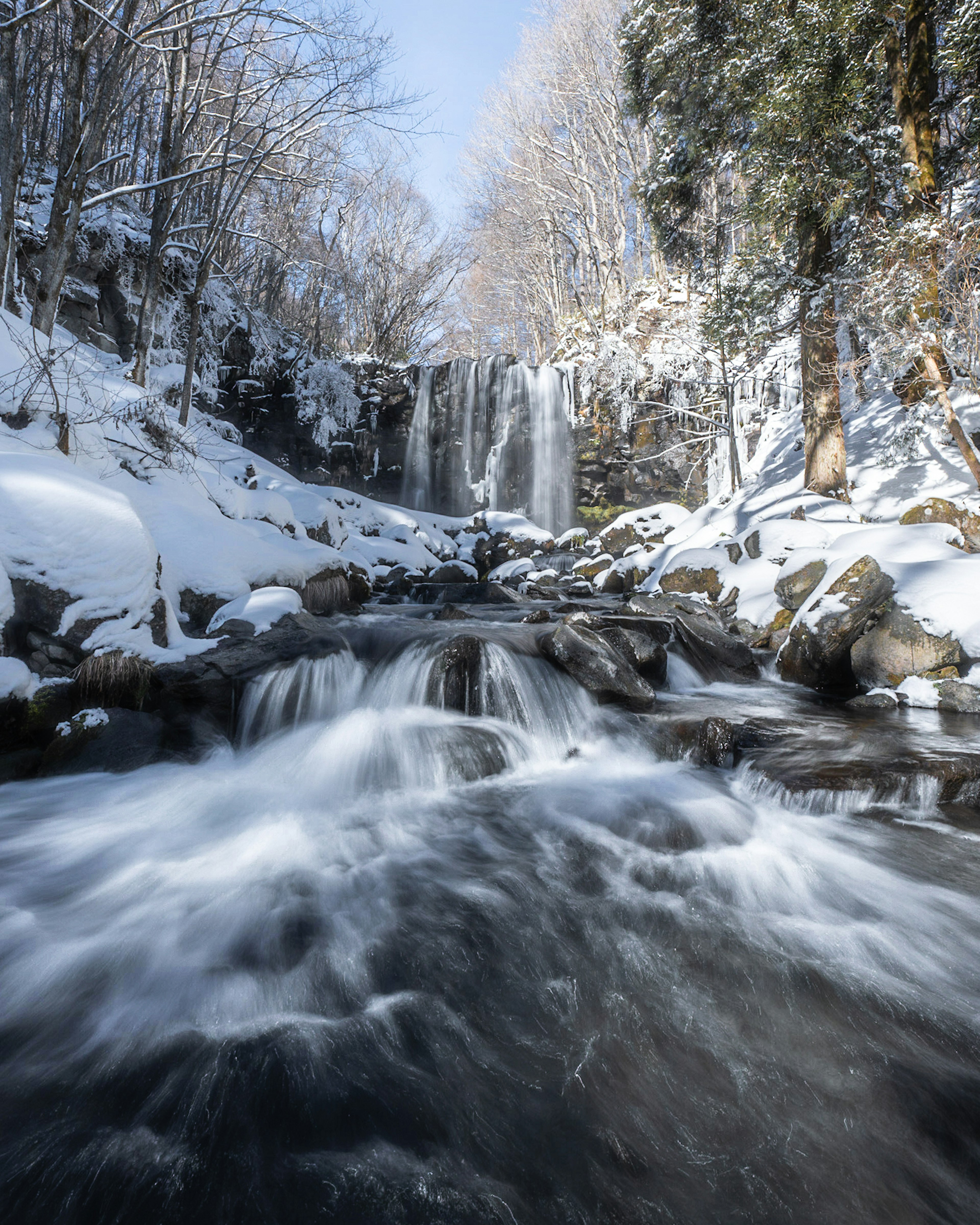 Beautiful landscape featuring a snowy waterfall and flowing water