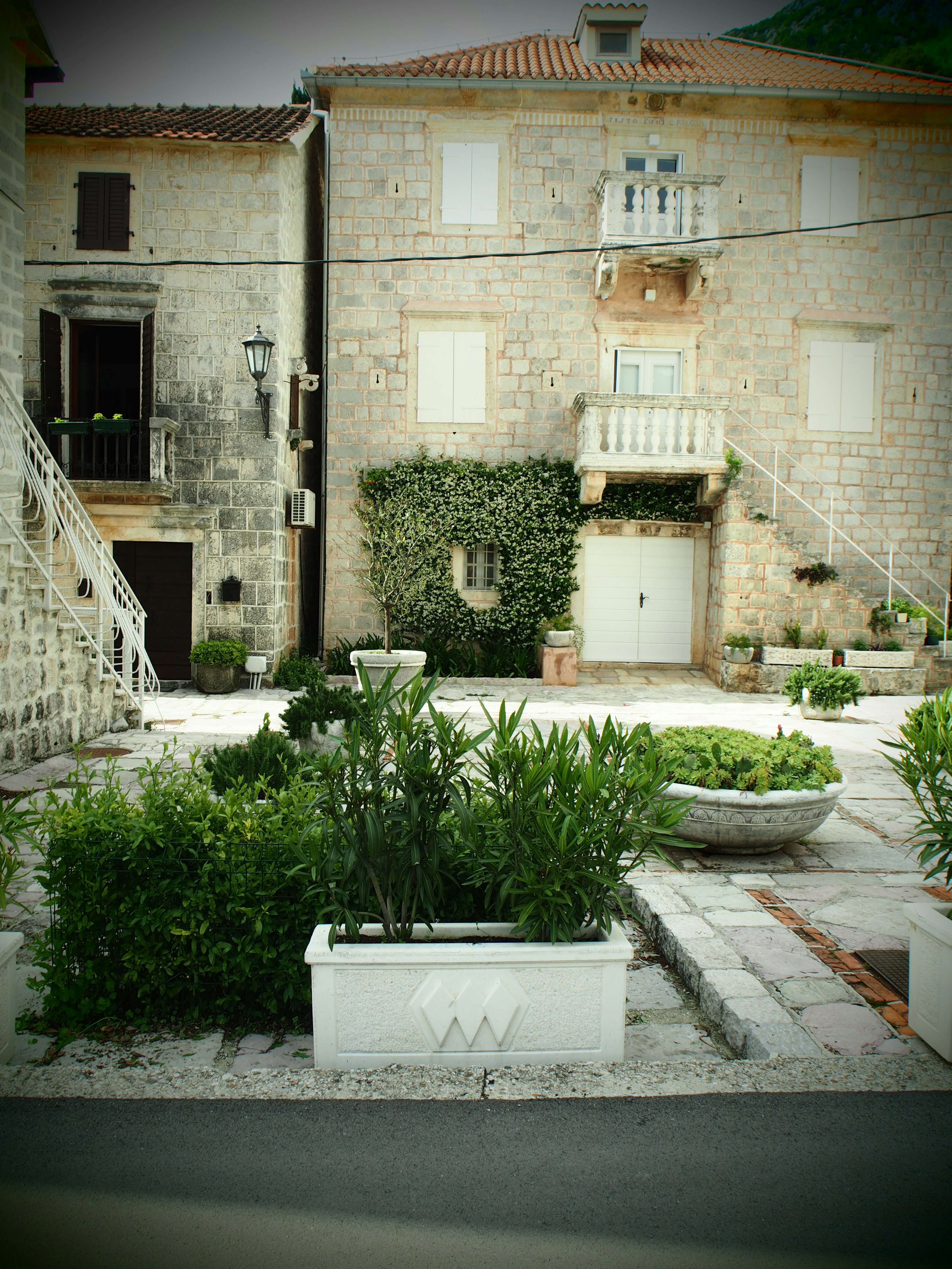 Quiet square with stone houses and lush greenery