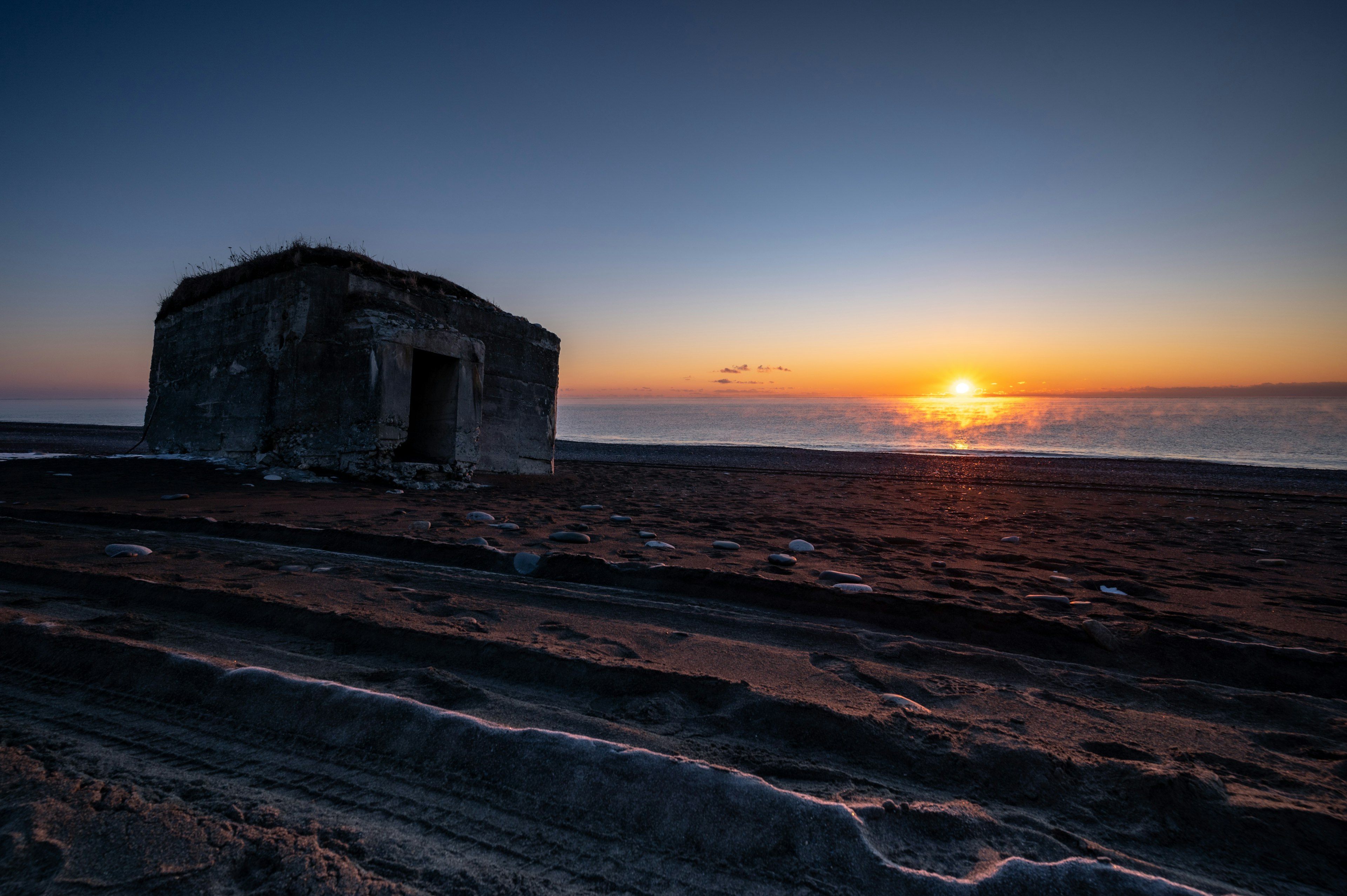 海辺にある廃墟の建物と美しい夕日