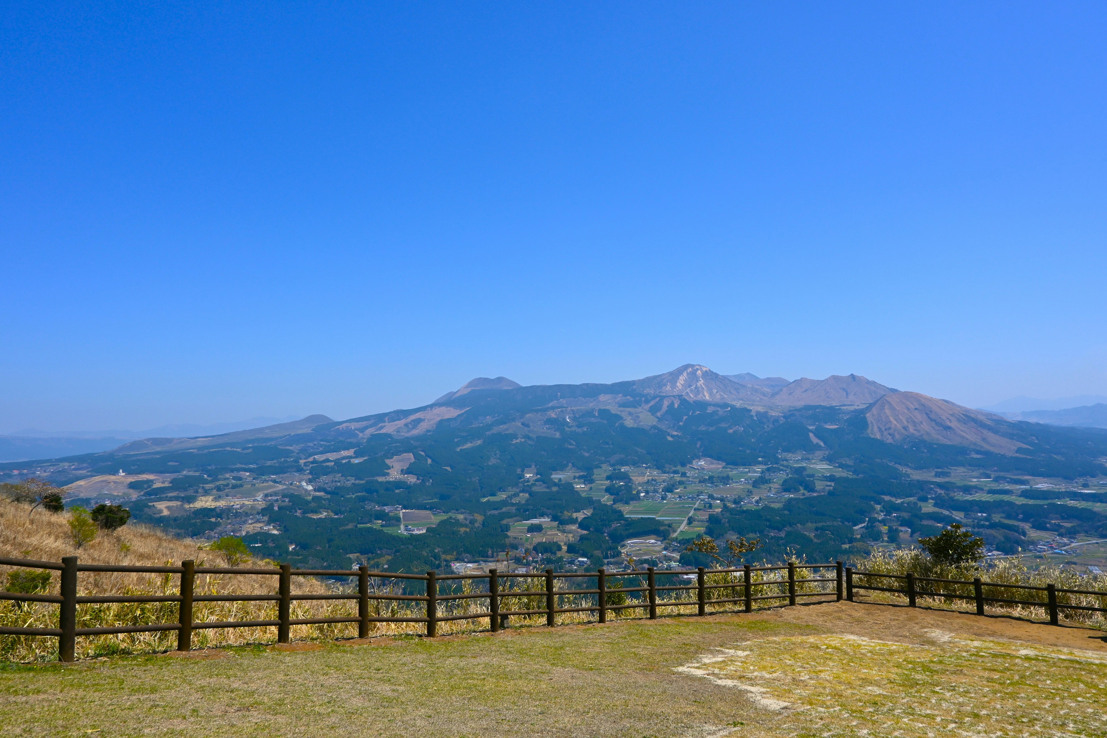 青空の下に広がる美しい山の風景と牧草地