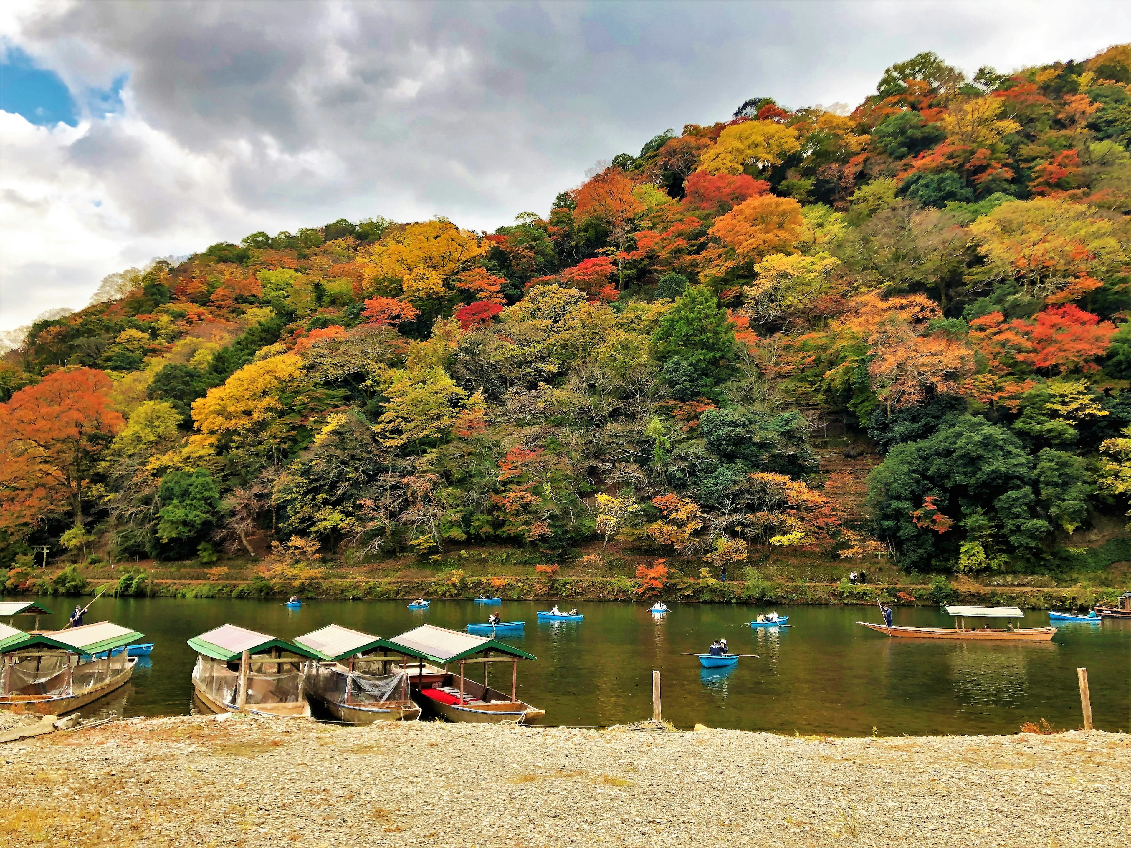 Malersches Herbstlandschaft mit bunten Bäumen und kleinen Booten auf einem ruhigen See