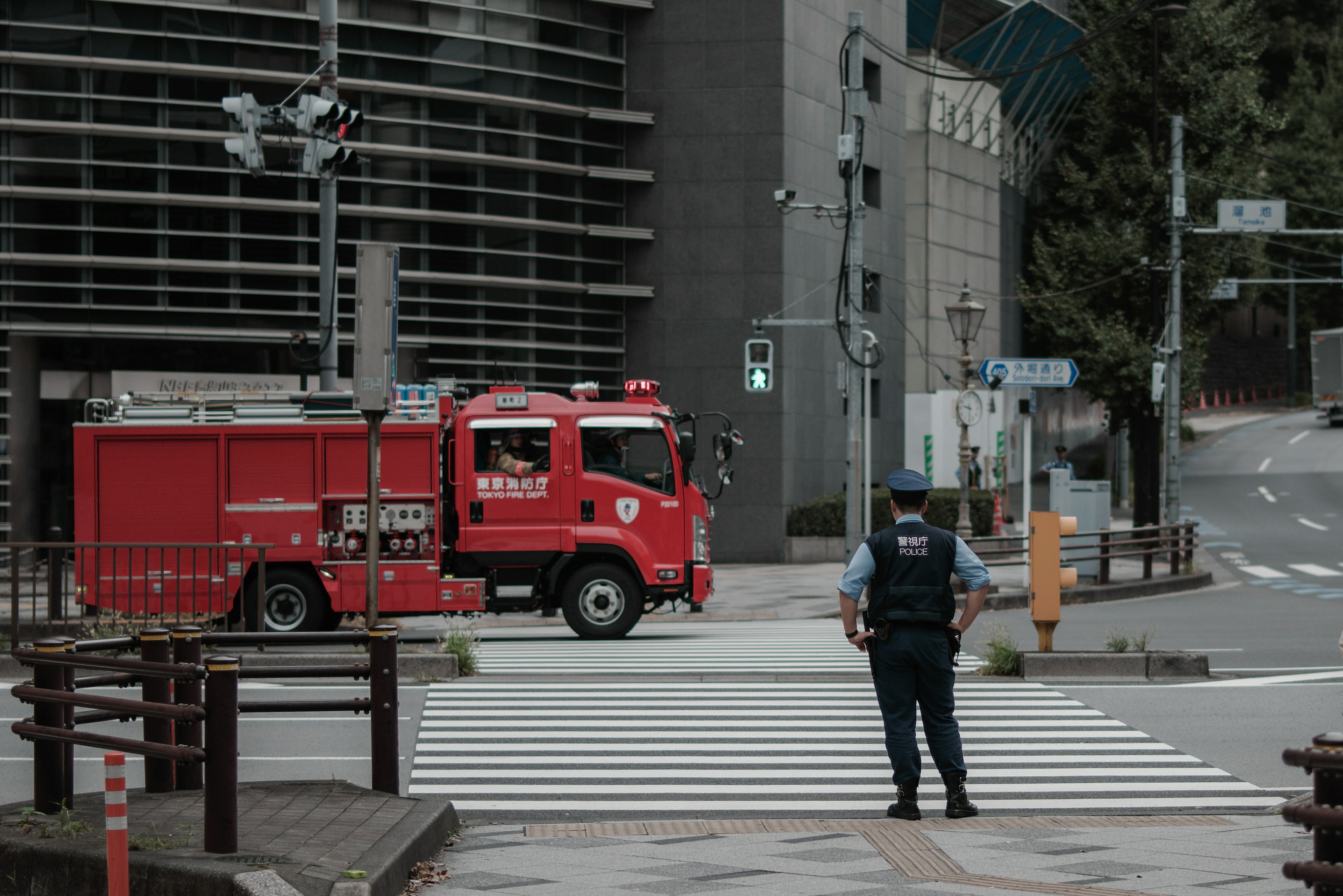 Scene at a crosswalk with a red fire truck and a police officer