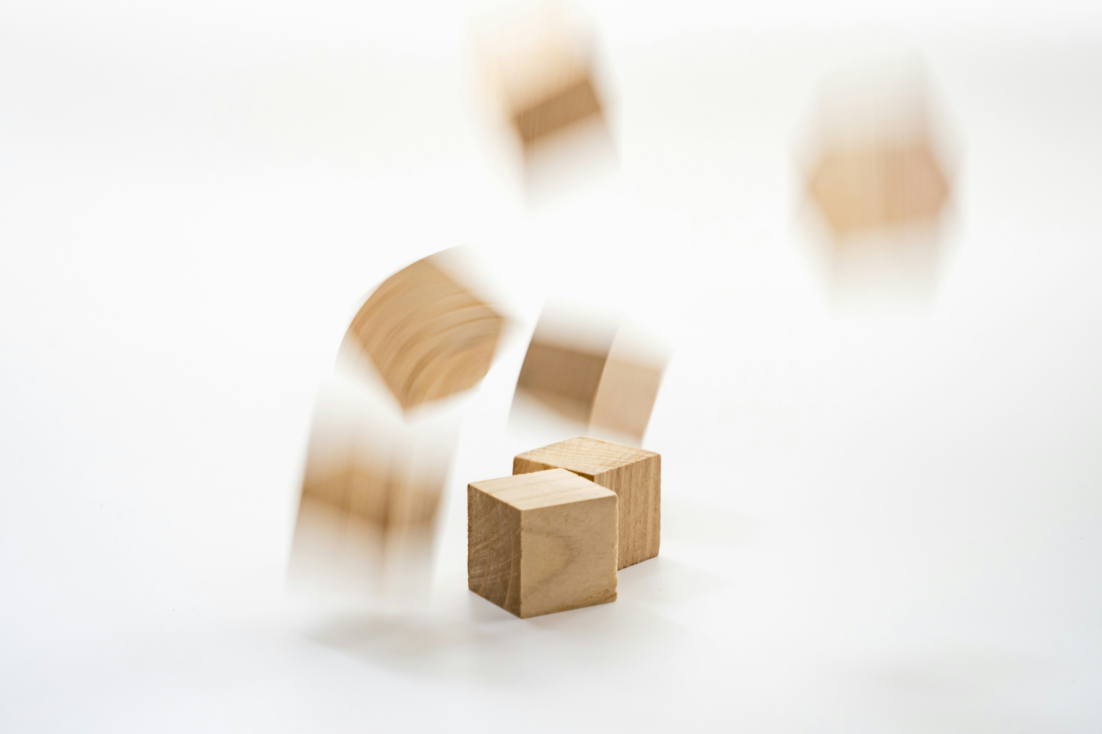 Floating wooden cubes in motion against a white background