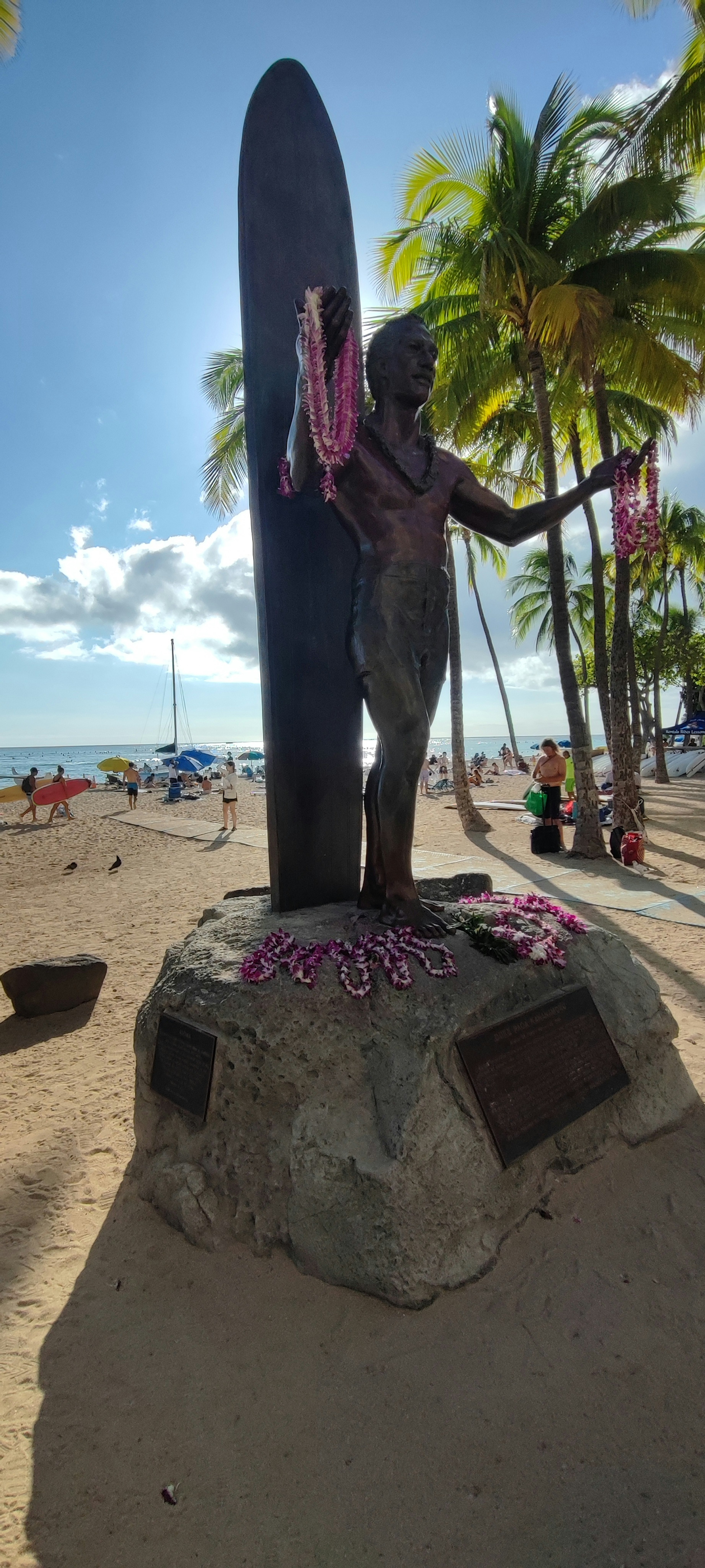 Statue de surf sur la plage avec des palmiers