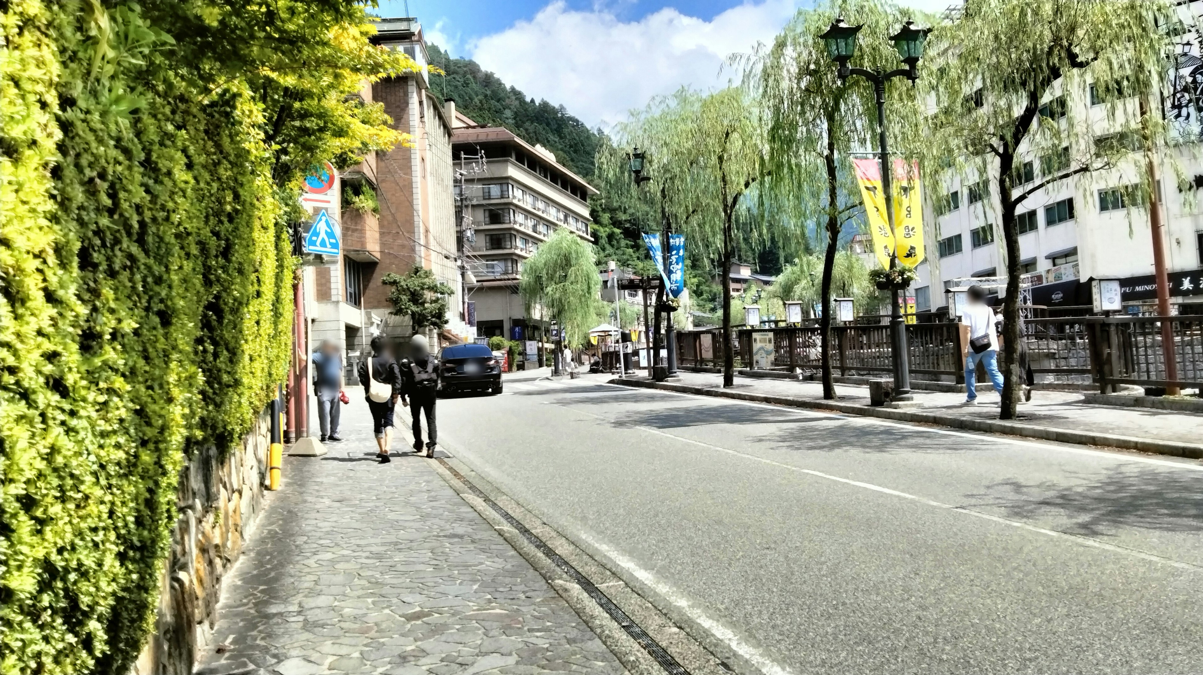 Straßenansicht mit grünem Laub und Gebäuden unter blauem Himmel