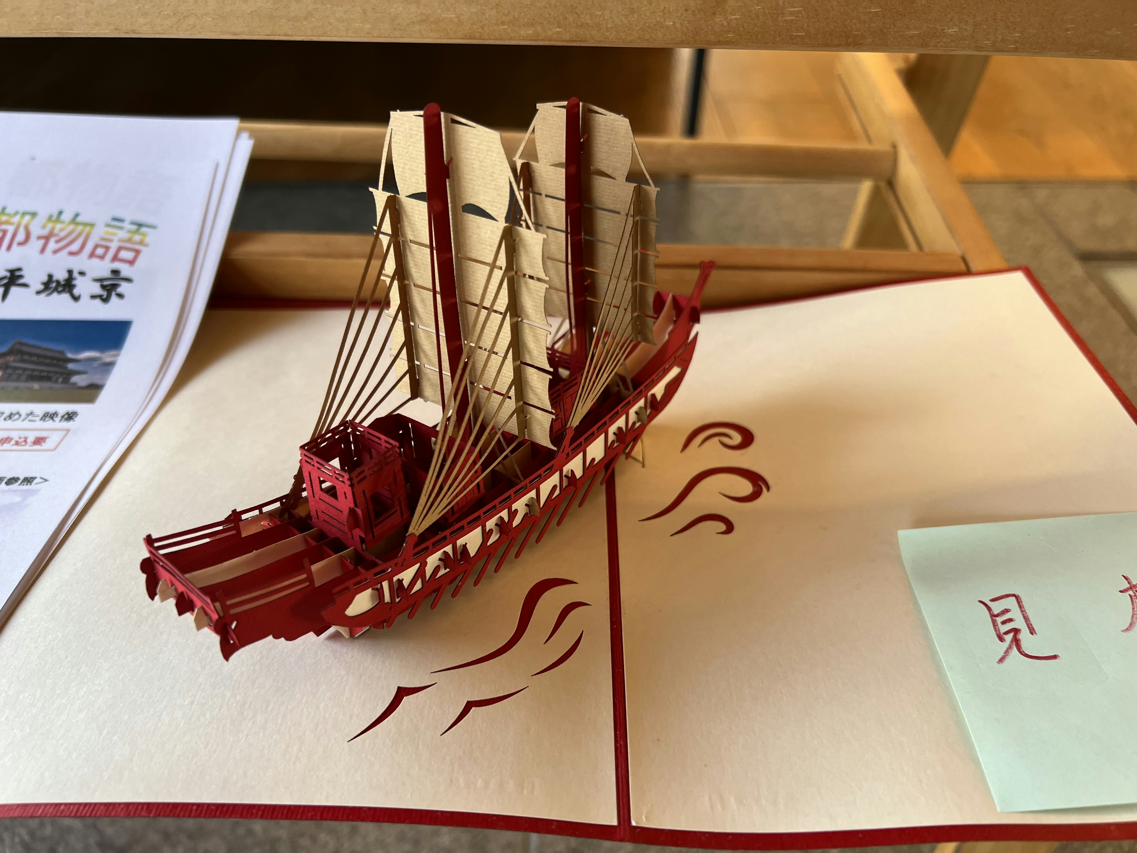 Colorful paper model of a ship placed on an open book