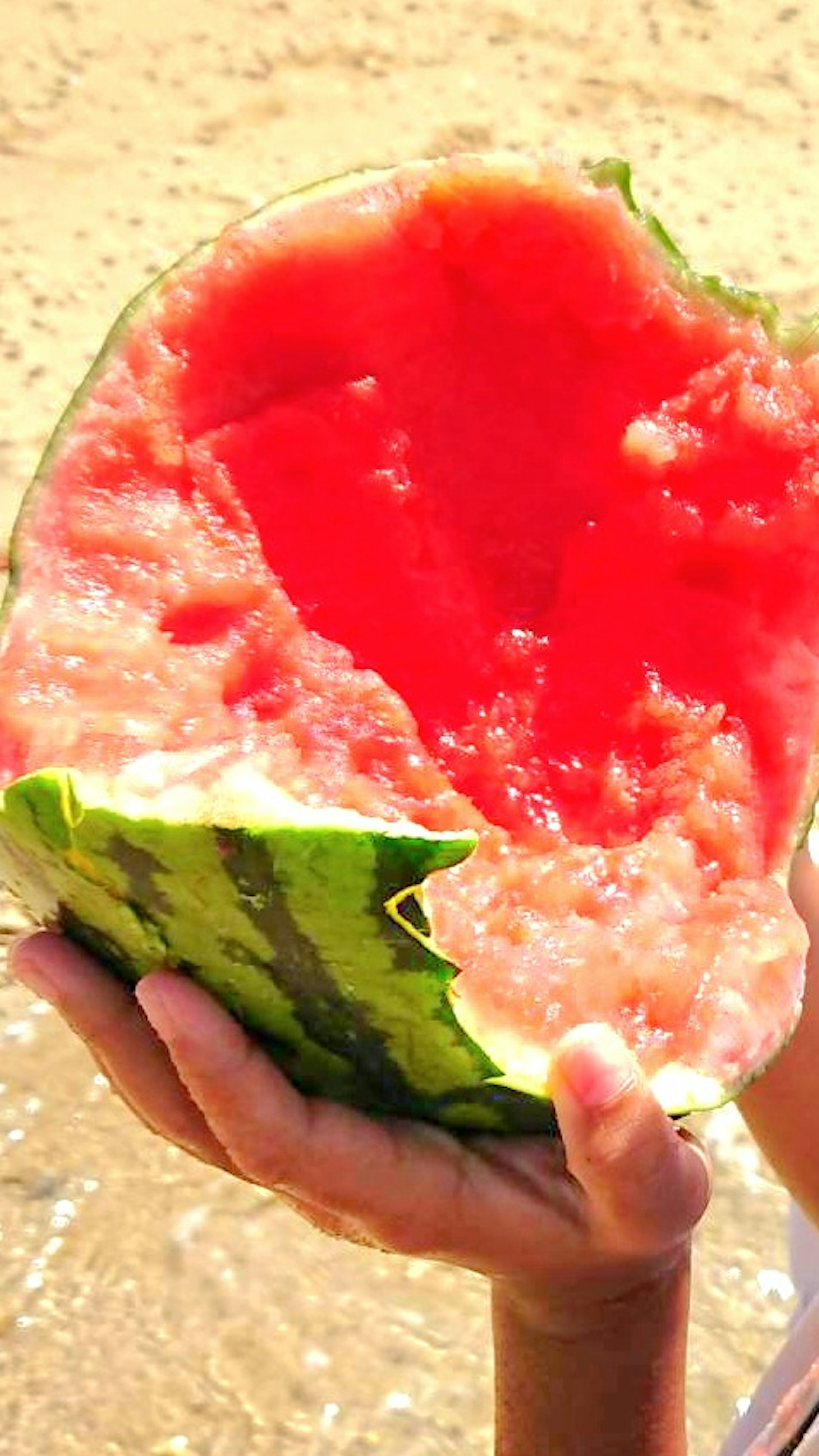 Mano sosteniendo una cáscara de sandía vacía con pulpa roja