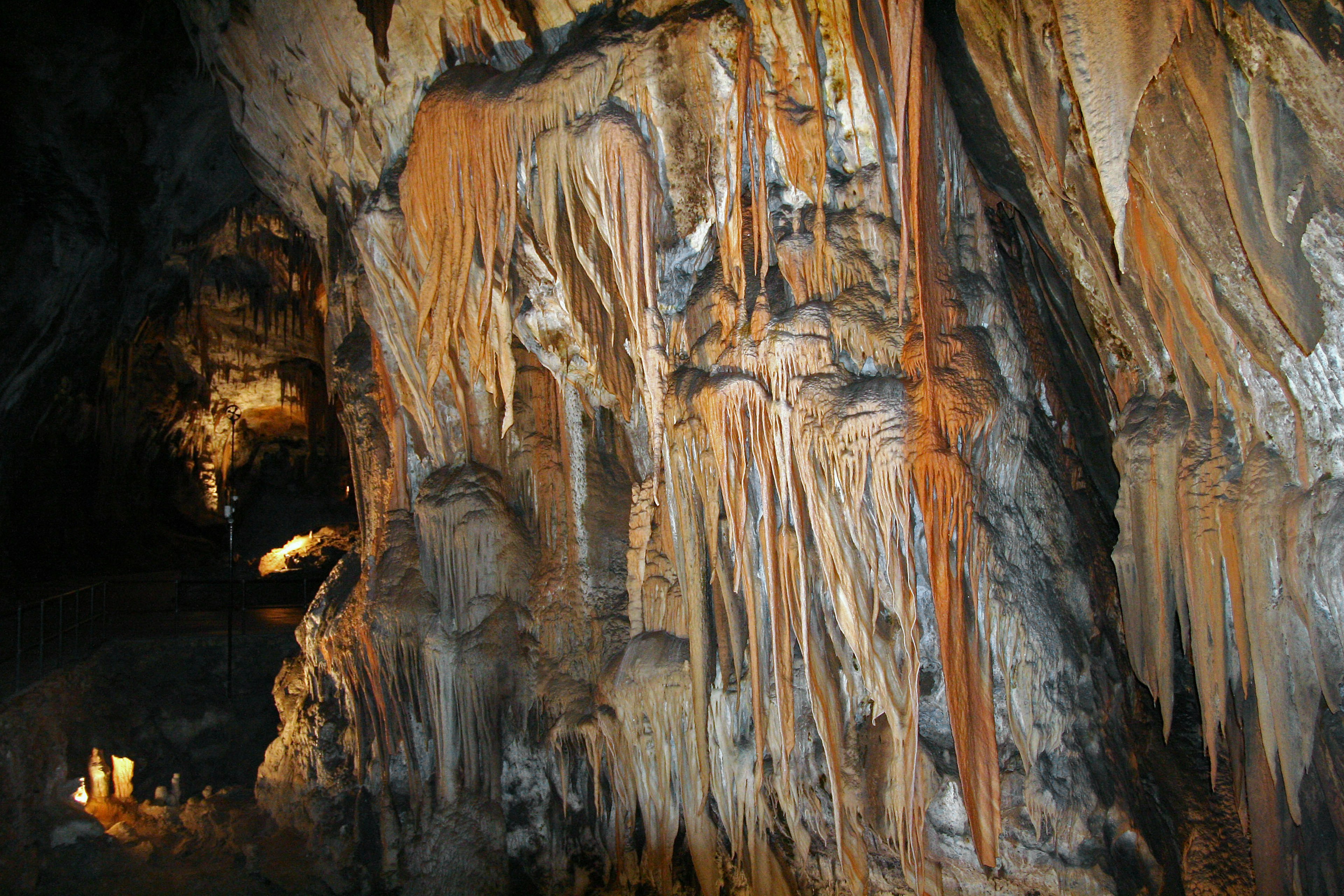 Dark cave featuring stalactites and stalagmites