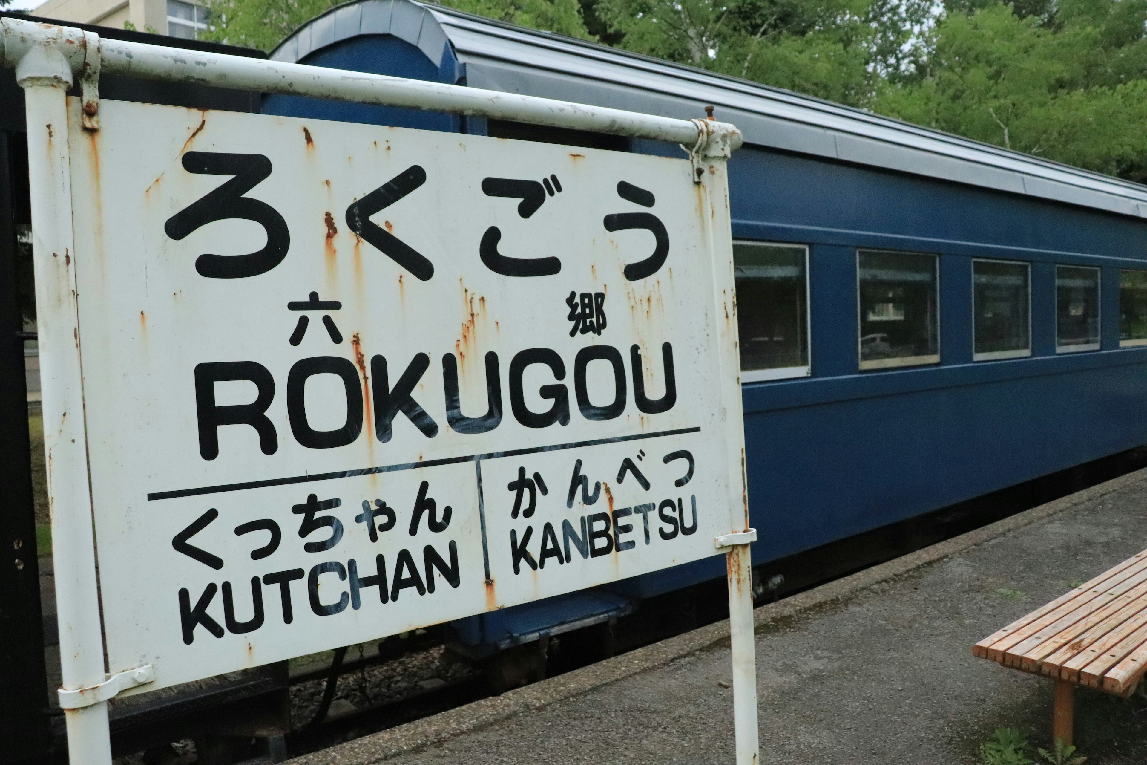 ろくごう駅の看板と青い列車の外観