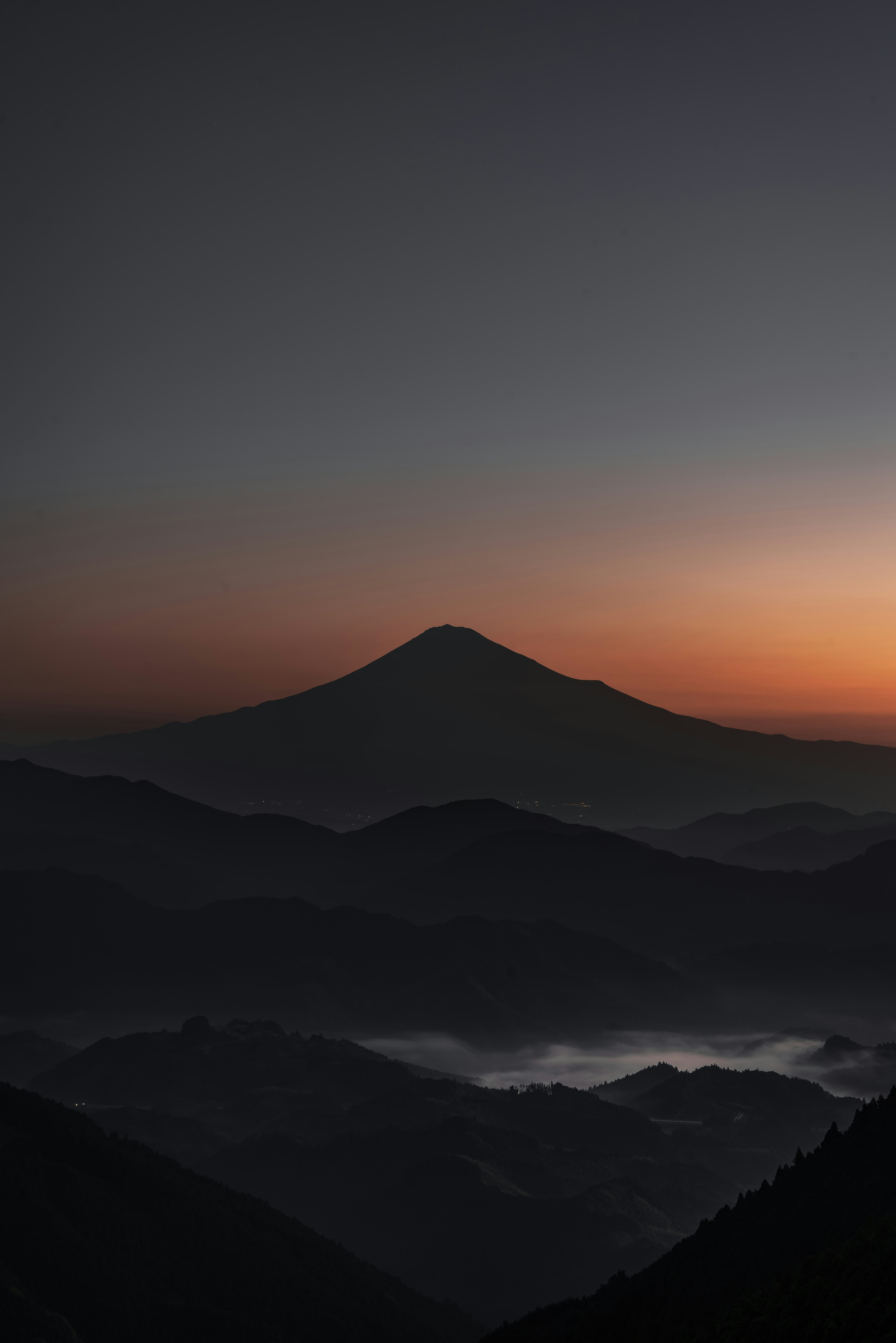 夕焼けに包まれた山々のシルエットと静かな雲海