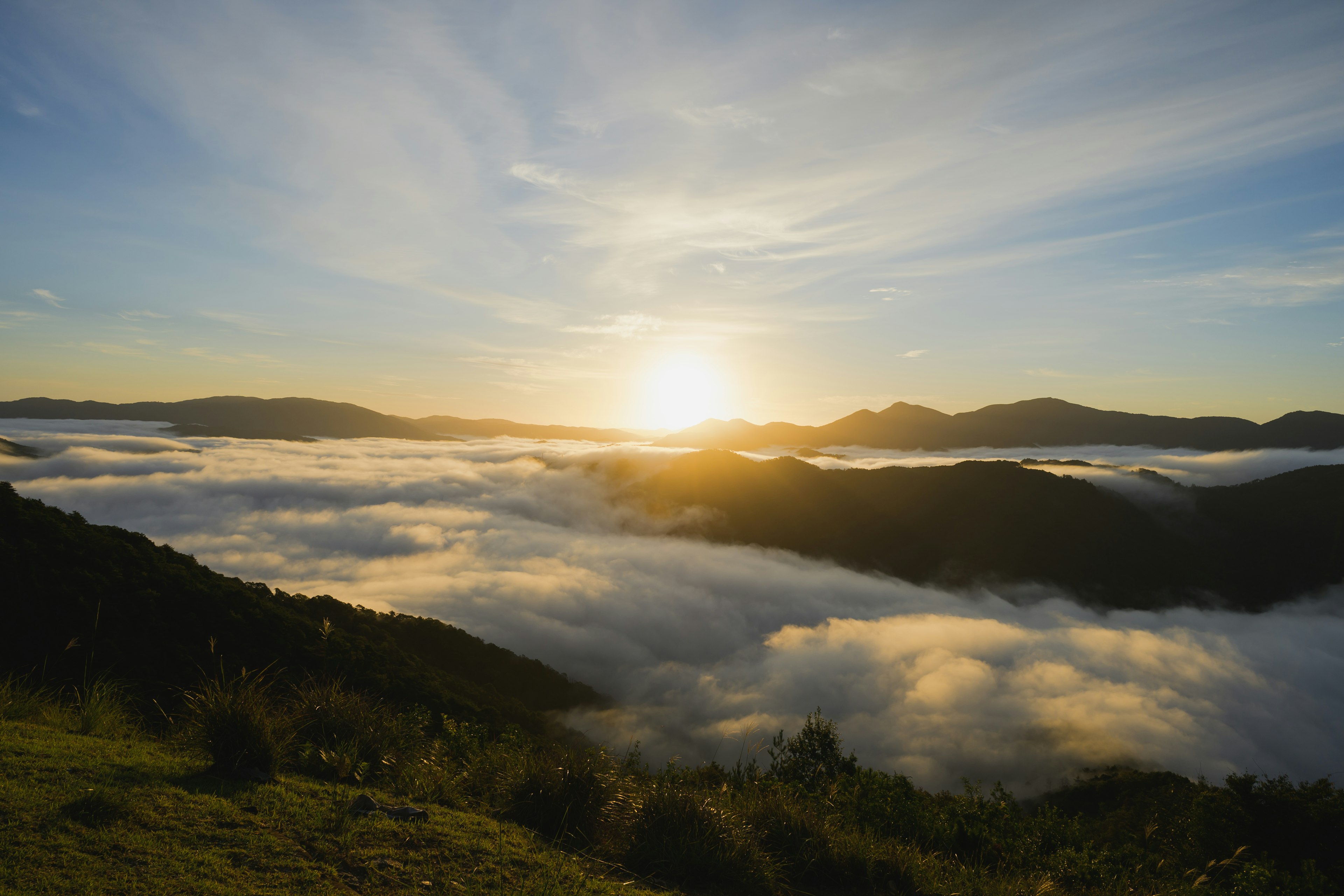 Scenic view of mountains enveloped in fog with a sunrise