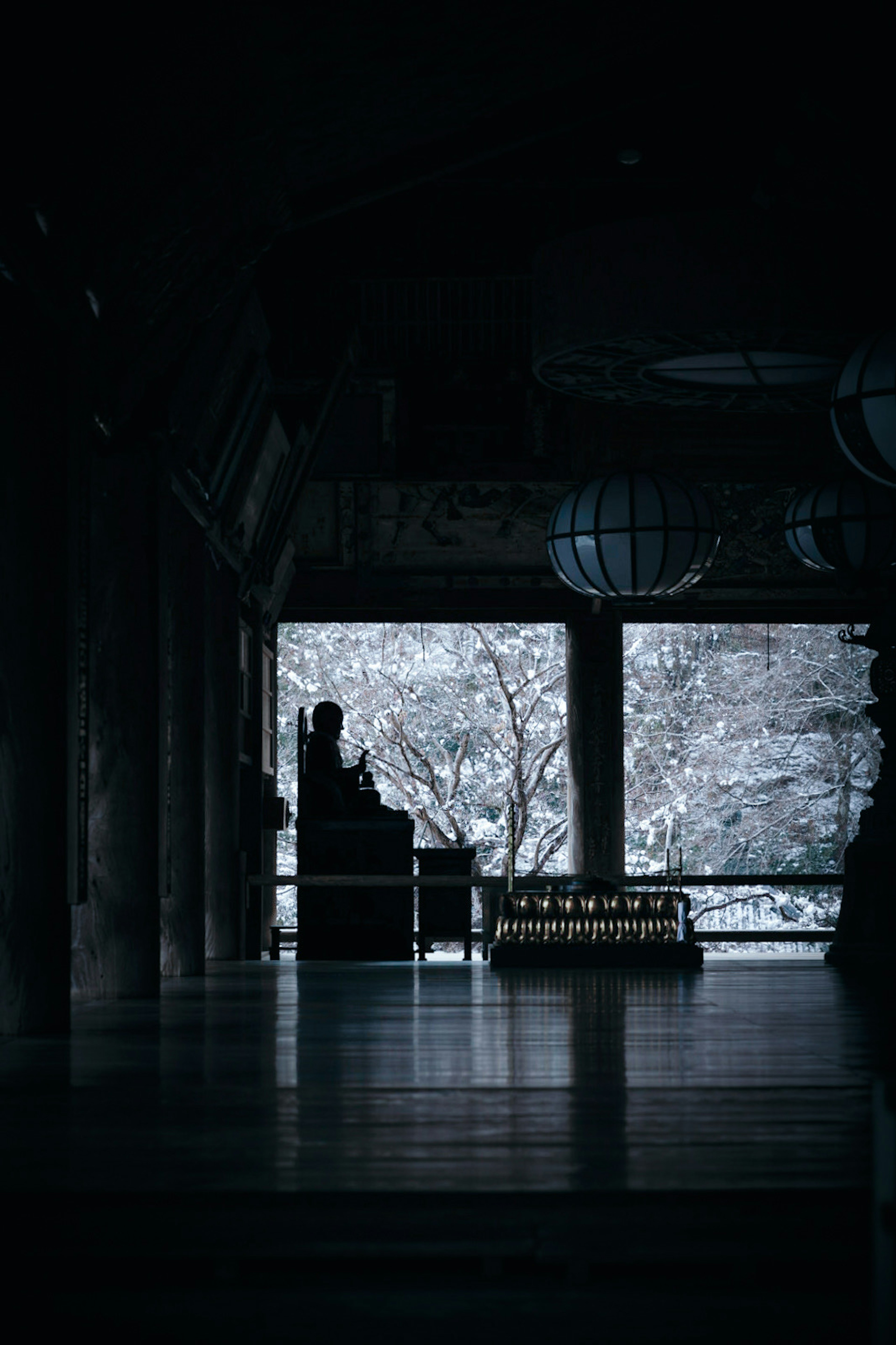 Quiet interior view with snow-covered trees visible through large windows