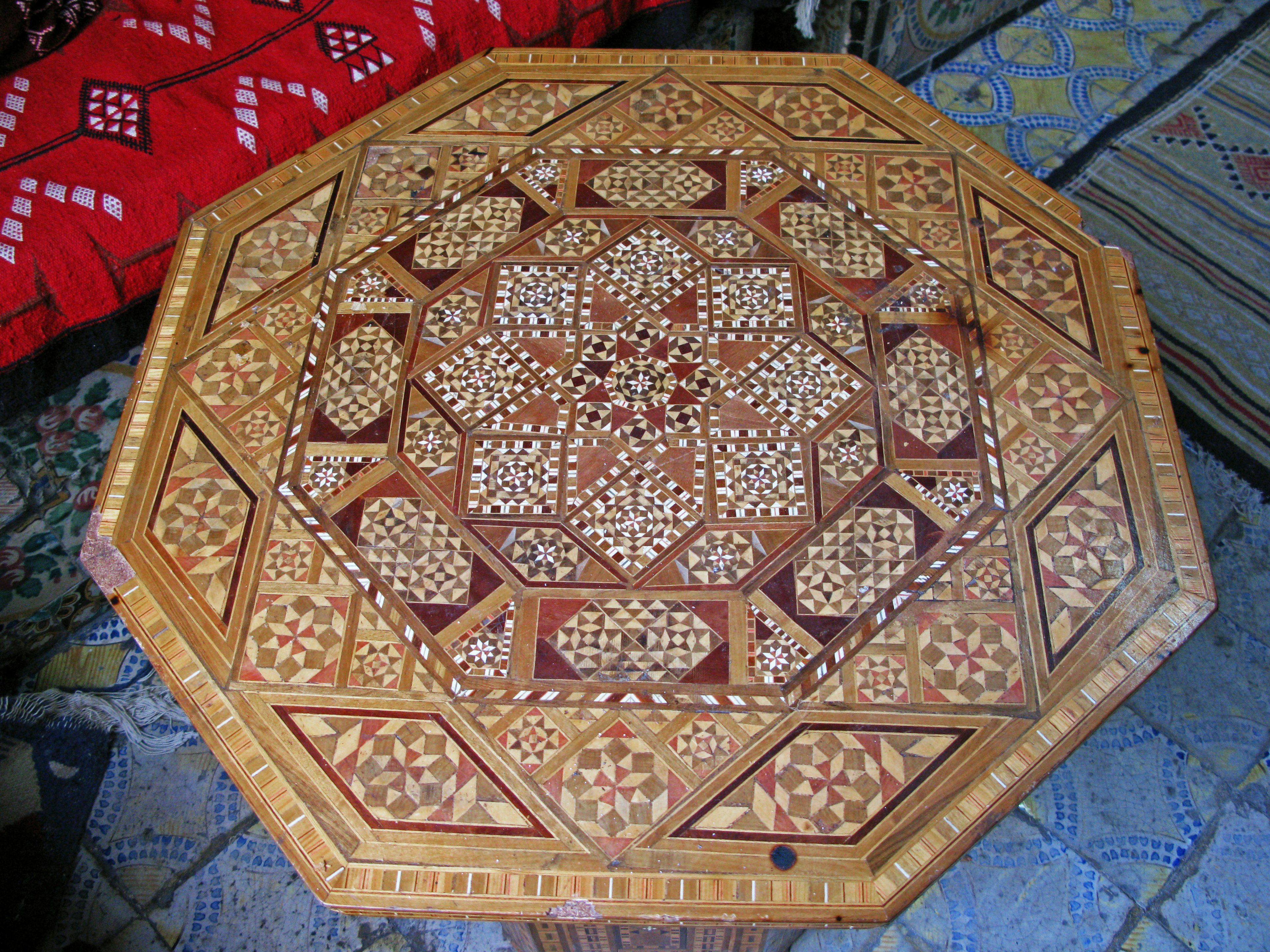 Intricate geometric patterns on the surface of an octagonal wooden table