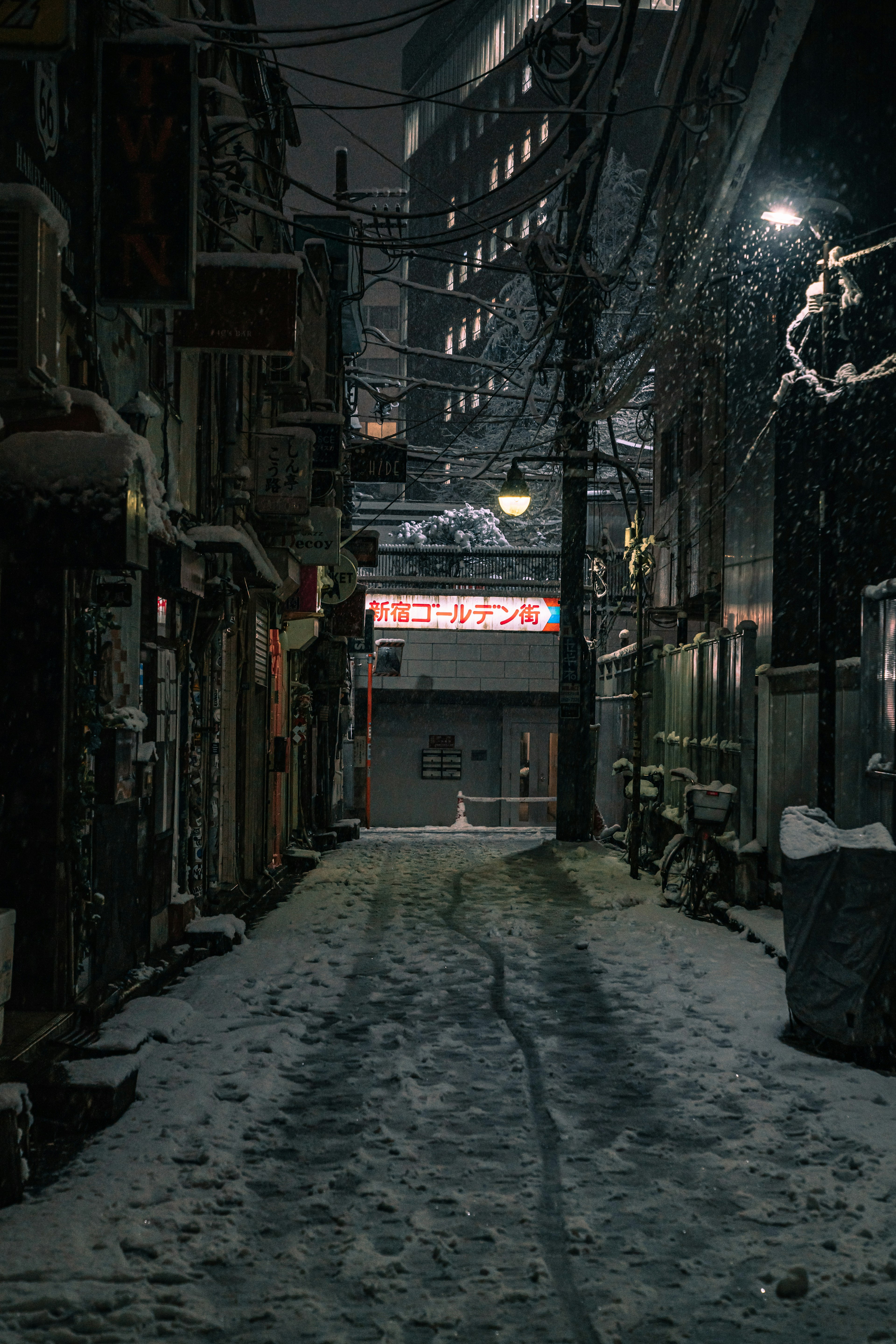 Calle nevada de noche con edificios y letreros de neón