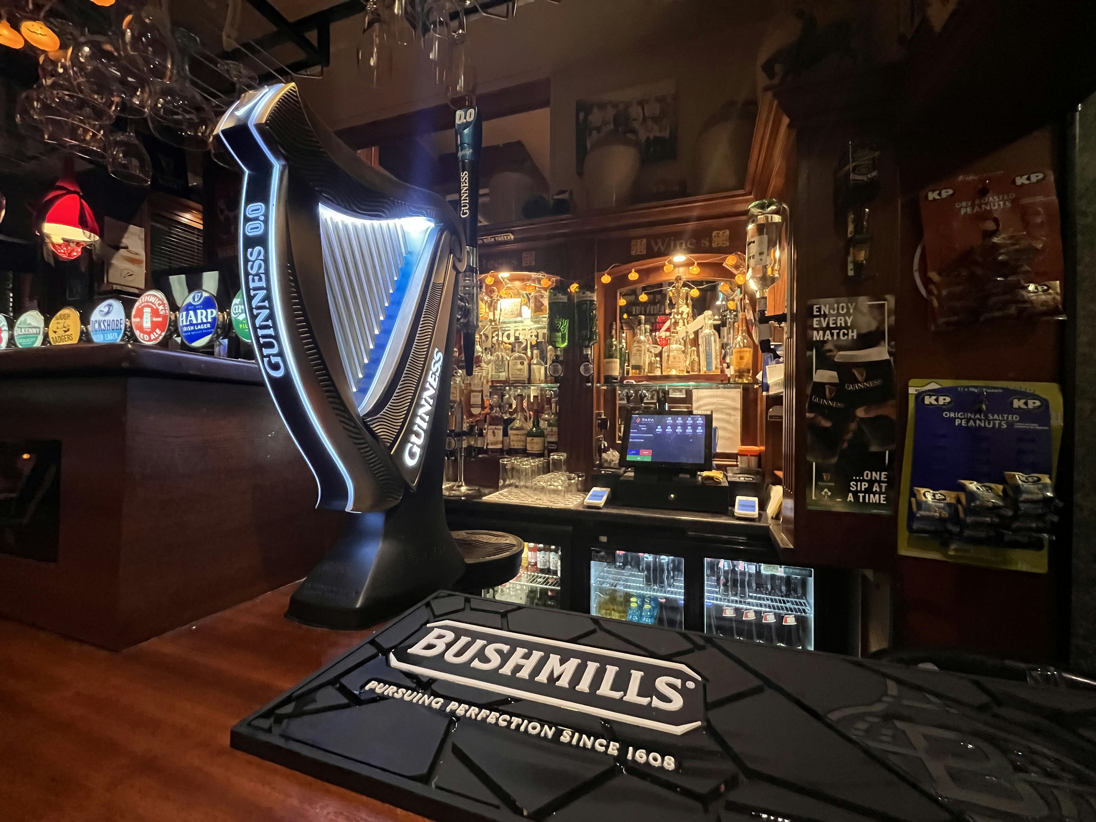 Supporto per bicchieri a forma di arpa su un bancone di bar con il logo Bushmills visibile